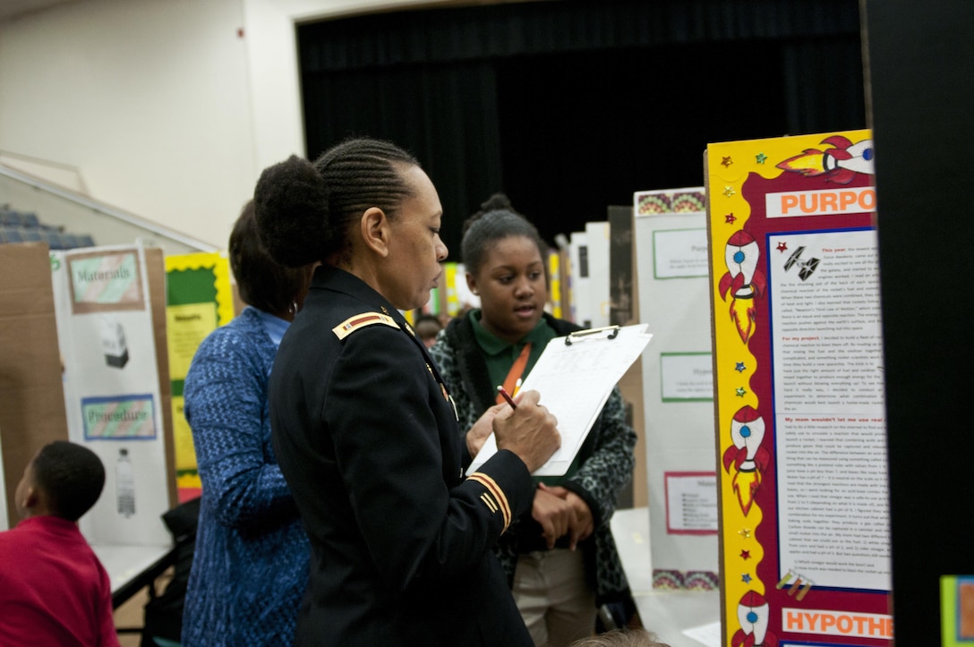 U.S. Army Reserve Chief Warrant Officer 4 Destria Gladney, transportation officer in charge, 412th Theater Engineer Command, listens and judges a project during the district science fair at the Vicksburg Auditorium in Vicksburg, Miss., Feb. 23. (U.S. Army photo by Staff Sgt. Debralee Best)