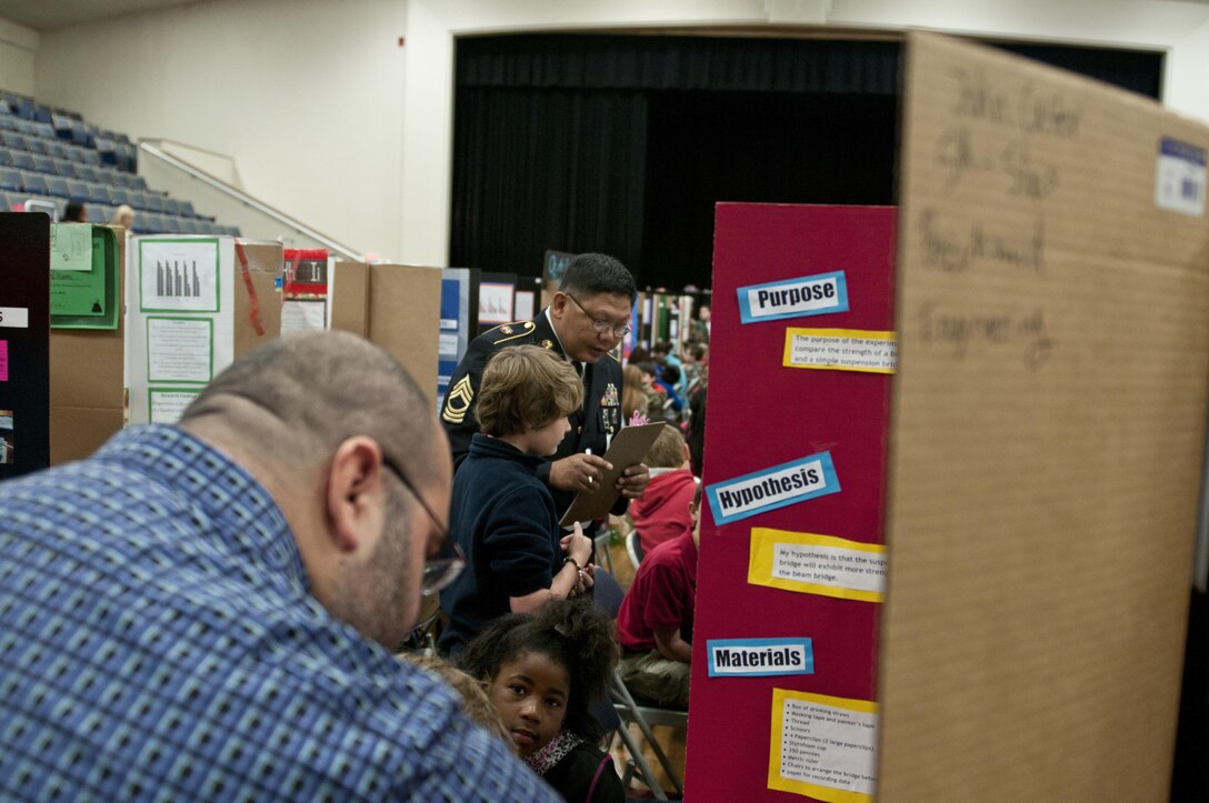 U.S. Army Reserve Master Sgt. Jaunito Bautista, senior maintenance noncommissioned officer in charge, 412th Theater Engineer Command, listens to a student while judging the district science fair at the Vicksburg Auditorium in Vicksburg, Miss., Feb. 23 to 24. (U.S. Army photo by Staff Sgt. Debralee Best)