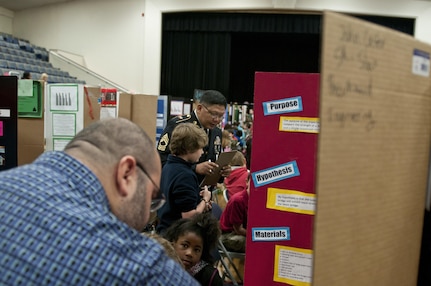 U.S. Army Reserve Master Sgt. Jaunito Bautista, senior maintenance noncommissioned officer in charge, 412th Theater Engineer Command, listens to a student while judging the district science fair at the Vicksburg Auditorium in Vicksburg, Miss., Feb. 23 to 24. (U.S. Army photo by Staff Sgt. Debralee Best)