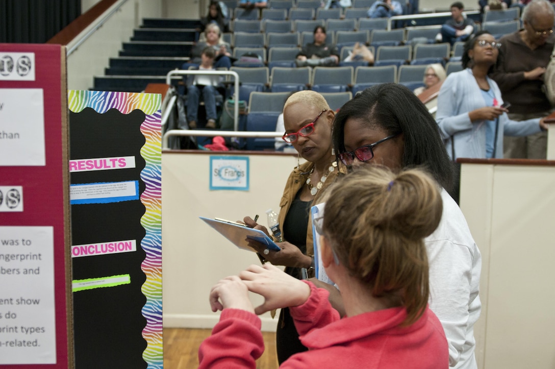 Pleshette Harris, suicide prevention coordinator, 412th Theater Engineer Command, judges a project at the district science fair at the Vicksburg Auditorium in Vicksburg, Miss., Feb. 23. (U.S. Army photo by Staff Sgt. Debralee Best)