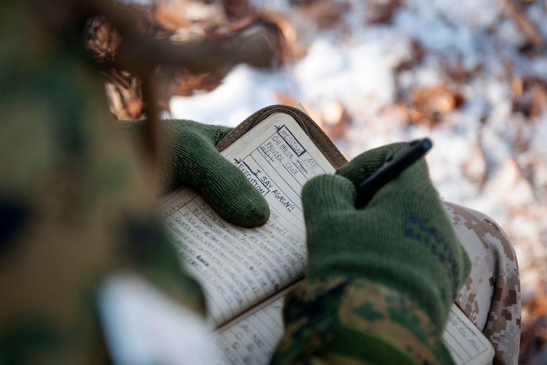 A Marine Corps officer candidate writes down notes during a small-unit leadership evaluation at Brown Field on Marine Corps Base Quantico, Va., Feb. 18, 2016. Marine Corps photo by Cpl. Patrick H. Owens