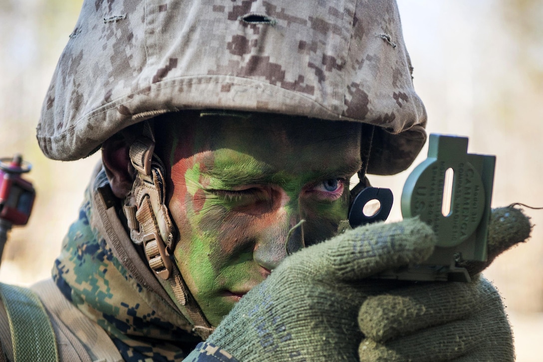 A Marine Corps officer candidate uses a lensatic compass to determine azimuth angles and bearings before proceeding to his next objective during a small-unit leadership evaluation at Brown Field on Marine Corps Base Quantico, Va., Feb. 18, 2016. Marine Corps photo by Cpl. Patrick H. Owens