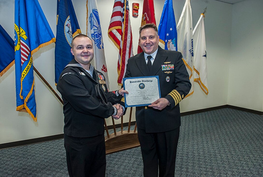 Petty Officer 2nd Class Anthony Brown reenlisted for eight more years in the Navy in a ceremony Feb. 29 presided by U.S. Navy Capt. Justin Debord, DLA Land and Maritime Chief of Staff, in Building 20. 