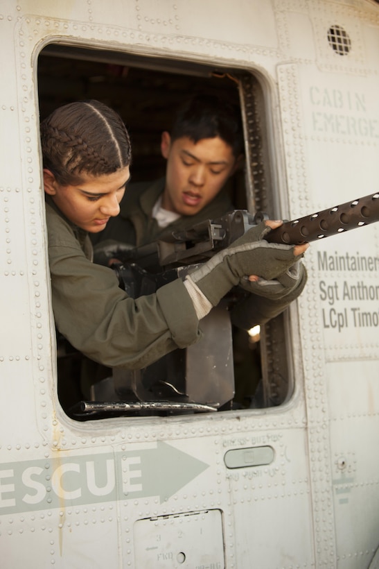 Lance Cpl. Samantha Alaw, left, and Cpl. Eun C. Lee mount a .50-caliber machine gun onto a CH-53E Super Stallion during Exercise Eager Response at Marine Corps Air Station Beaufort, S.C., Feb. 25, 2016. During the exercise, Marines trained in events such as casualty evacuation, assault support missions and aerial refueling, proving the 2nd Marine Aircraft Wing is a highly effective combat force. Alaw is a CH-53E crew chief with Marine Heavy Helicopter Squadron 366, and Lee is a CH-53E airframe mechanic with HMM-366. (U.S. Marine Corps photo by Pfc. Nicholas P. Baird/Released)