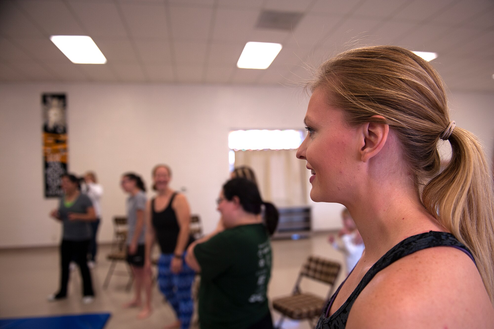 U.S. Air Force Staff Sgt. Adriene Anderson, 315th Training Squadron instructor, grins during a self-defense class at St. Marks Presbyterian Church, San Angelo, Texas, Feb. 27, 2016. Anderson initiated the Mommy Fit Camp program in August of 2015 as part of the Make Goodfellow Great Initiative for Goodfellow Air Force Base. (U.S. Air Force photo by Airman 1st Class Caelynn Ferguson/Released)