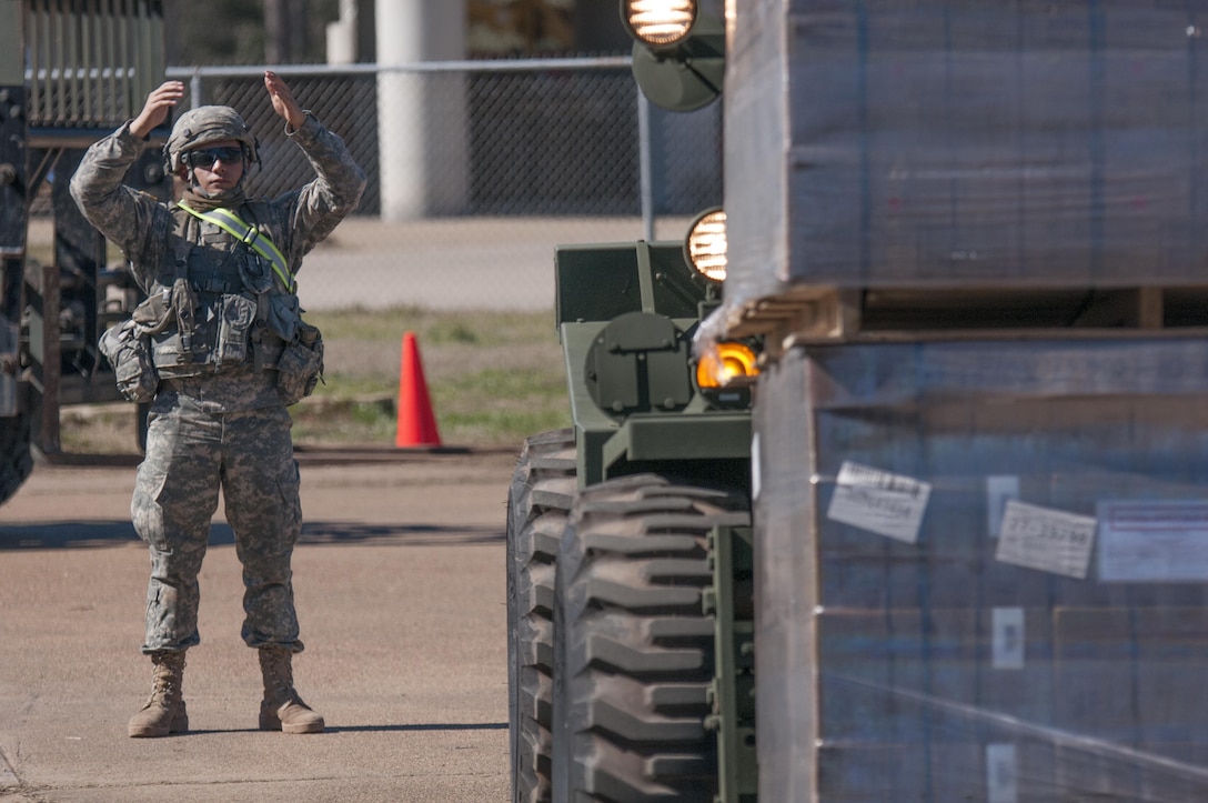 Spc. Robin Trinidad, an automated logistics specialist from the 103rd Quartermaster Company in Houston, Texas, guides a pallet of Meals Ready to Eat on Feb. 17, 2016 at Fort Polk, La. while supporting a field training. The Army Reserve unit is providing Class I supplies during the exercise in partnership with active Army units and foreign service members.  (U.S. Army photo by Sgt. Brandon Hubbard, 204th PAD)