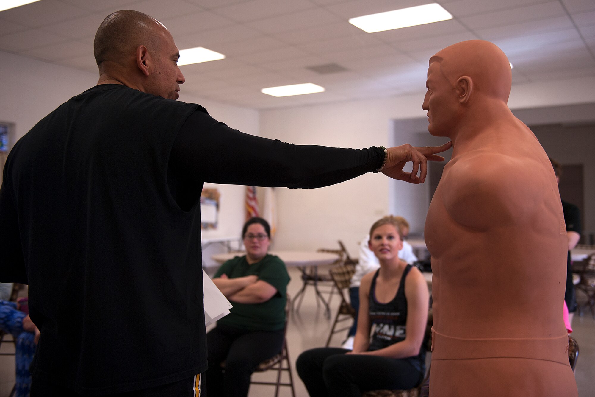 Mark E. Ledesma, 315th Training Squadron emerging technologies chief, points to specific target areas to attack during a self-defense class at St. Marks Presbyterian Church, San Angelo, Texas, Feb. 27, 2016. Ledesma, who also teaches ‘Target Hardening Self-Defense’ classes externally, taught the Mommy Fit Camp members for free.  (U.S. Air Force photo by Airman 1st Class Caelynn Ferguson/Released)
