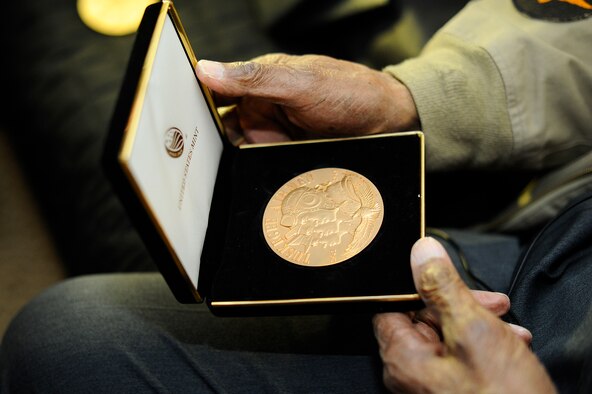 Retired Maj. George Boyd exhibits a Congressional Gold Medal at his home in Wichita, Kan., Feb. 4, 2016. Boyd is a 28-year combat veteran and member of the famous Tuskegee Airmen. Boyd received two Congressional Gold Medals, one as a member of the Tuskegee Airmen and the other as part of the U.S. Civil Air Patrol. (U.S. Air Force photo/Airman Jenna K. Caldwell)