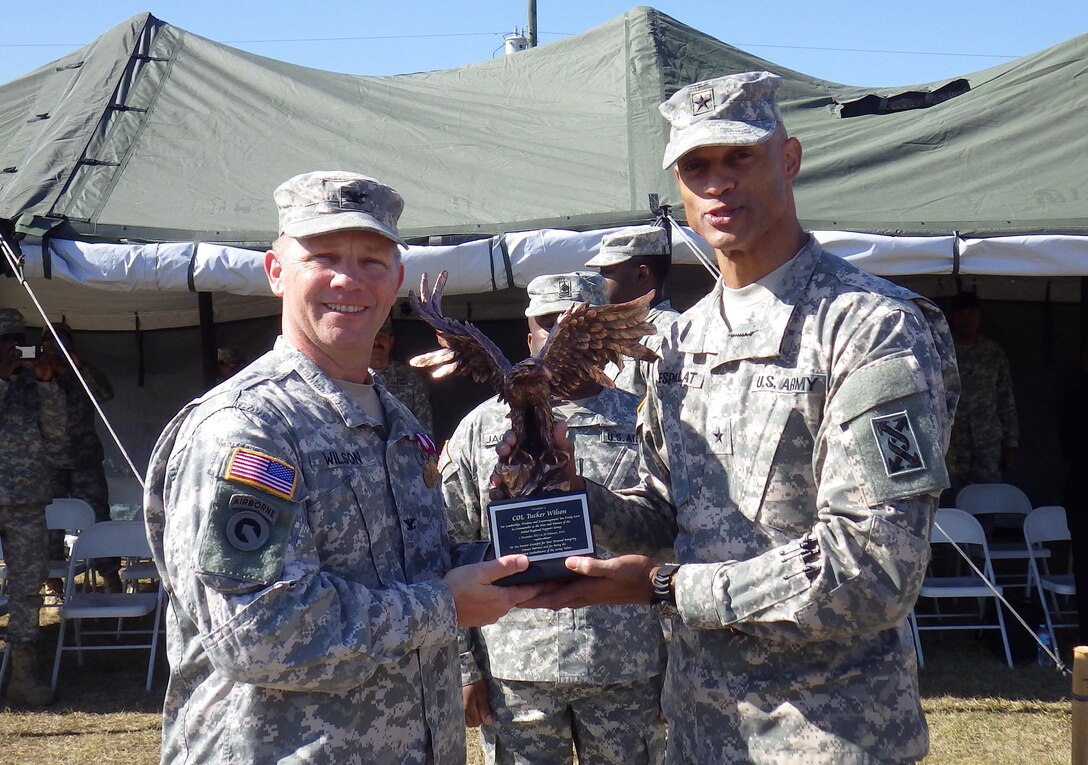 From left, U.S. Army Col. James T. Wilson accepts a gift honoring his time commanding the 642nd Regional Support Group from Brig. Gen. Francisco A. Espaillat, commander of the 143rd Sustainment Command (Expeditionary), Feb. 28 at Fort Stewart, Ga. Wilson stepped down from command of the brigade to lead a portion of the unit to Fort Bliss, Texas, where they will process troops going through mobilization and demobilization. Col. Jeffrey L. Richar is now in command of the 642nd RSG.