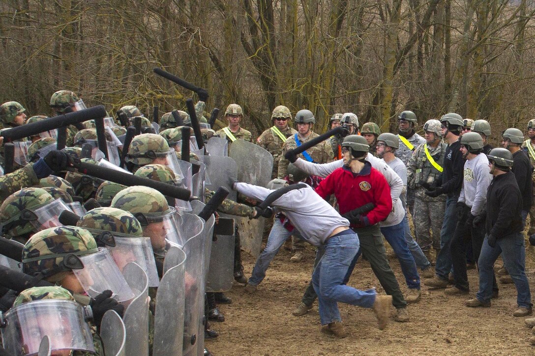 A group of mock protesters attack a wall of Albanian and U.S. soldiers during crowd control training at the Joint Multinational Readiness Center in Hohenfels, Germany, Feb. 25, 2016. Army photo by Staff Sgt. Thomas Duval