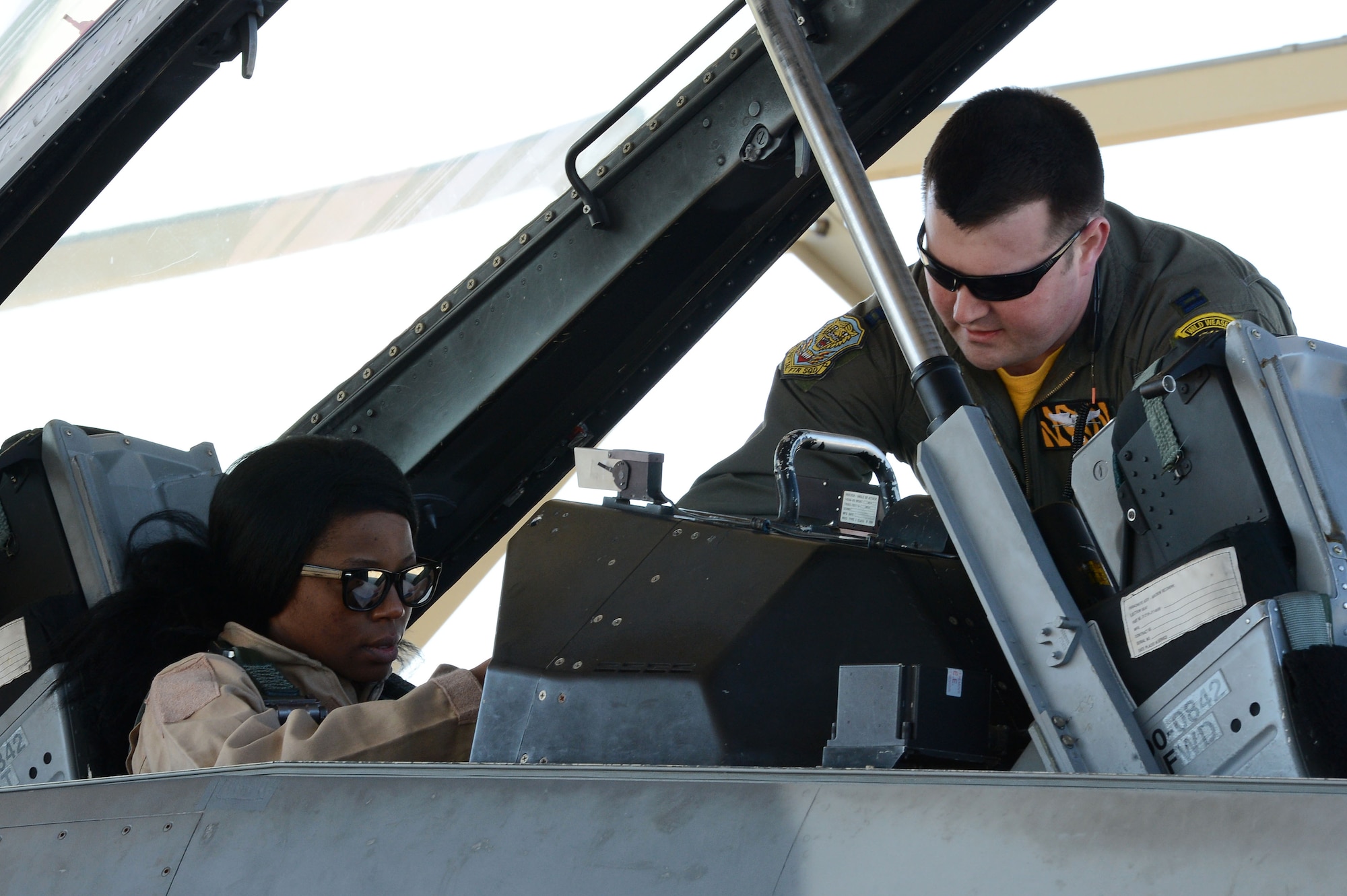 U.S. Air Force Capt. Nathaniel Halley, 20th Fighter Wing chief of wing inspections, secures Niza Baber, wife of Senior Airman Stephen Baber, 20th Aircraft Maintenance Squadron aircraft electrical and environmental systems technician, into an F-16DM in preparation for a spouse taxi event at Shaw Air Force Base, S.C., Feb. 26, 2016. Spouse taxis give dependents of aircraft maintenance personnel and pilots the opportunity to ride in an F-16 in order to better understand the work their significant others do. (U.S. Air Force photo by Senior Airman Zade Vadnais)