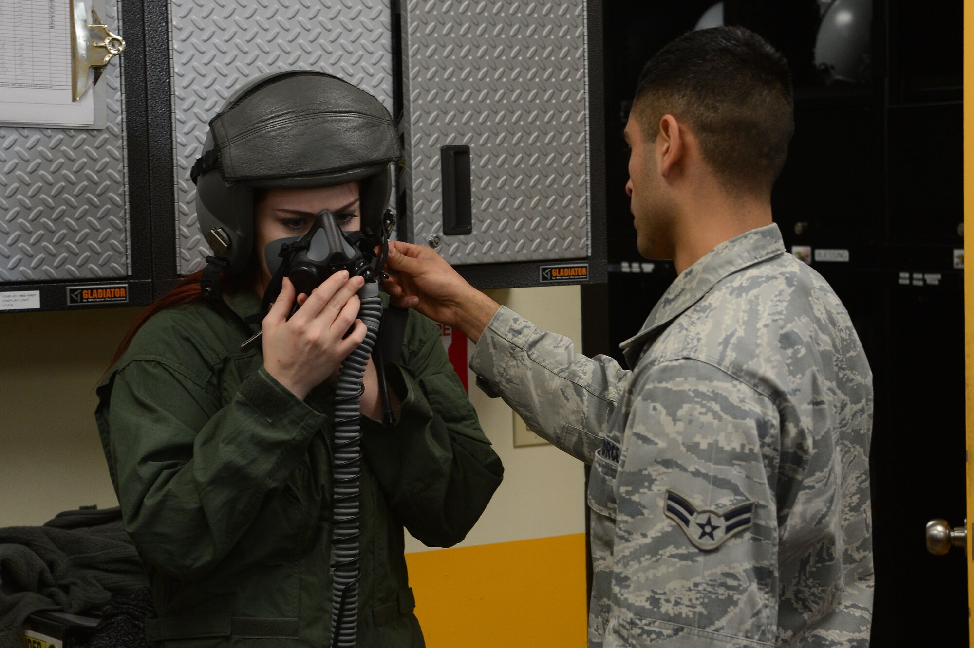 Ariana Nagel, wife of U.S. Air Force Senior Airman Sean Nagel, 20th Aircraft Maintenance Squadron aerospace propulsion technician, tries on flight gear in preparation for a spouse taxi event at Shaw Air Force Base, S.C., Feb. 26, 2016. Spouse taxis provide the family members of Airmen who work with aircraft first-hand experience with the jets. (U.S. Air Force photo by Senior Airman Zade Vadnais)