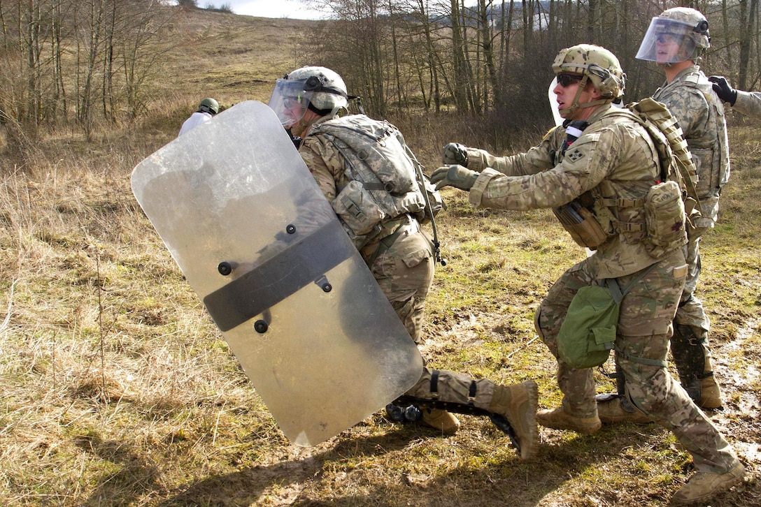 U.S. soldiers chase a mock protester during crowd control training at the Joint Multinational Readiness Center in Hohenfels, Germany, Feb. 25, 2016. Army photo by Staff Sgt. Thomas Duval