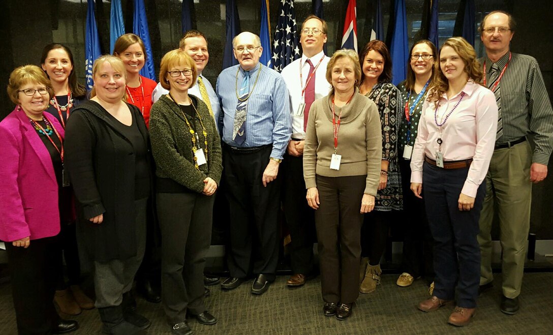 The Omaha District Office of Counsel surround the outgoing District Counsel, Rick Totten, while supporting the incoming District Counsel, and former Deputy Chief Counsel, Tom Tracy. They are from left, Linda Doll, Stacy Birkel, Alecia Dembowski, Erin Murphy, Cathy Grow, Jim Pakiz, Richard Totten, Tom Tracy, Linda Burke, Melissa Head, Amanda Lyon, Stephanie Frazier and Stan Tracey. Not shown is Tom Ingram.