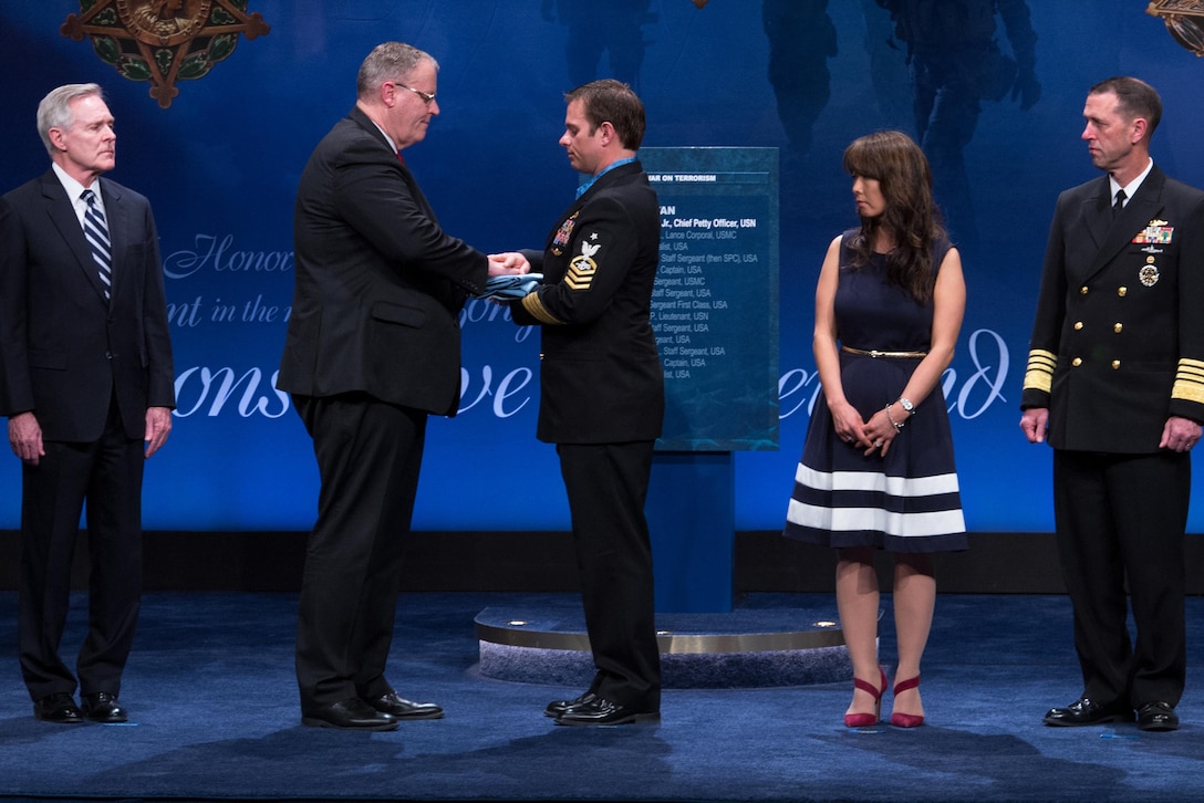 Deputy Defense Secretary of Defense Bob Work presents the Medal of Honor flag to Medal of Honor recipient Navy Senior Chief Petty Officer Edward C. Byers Jr. during a ceremony to induct him into the Hall of Heroes at the Pentagon, March 1, 2016. DoD News photo by EJ Hersom