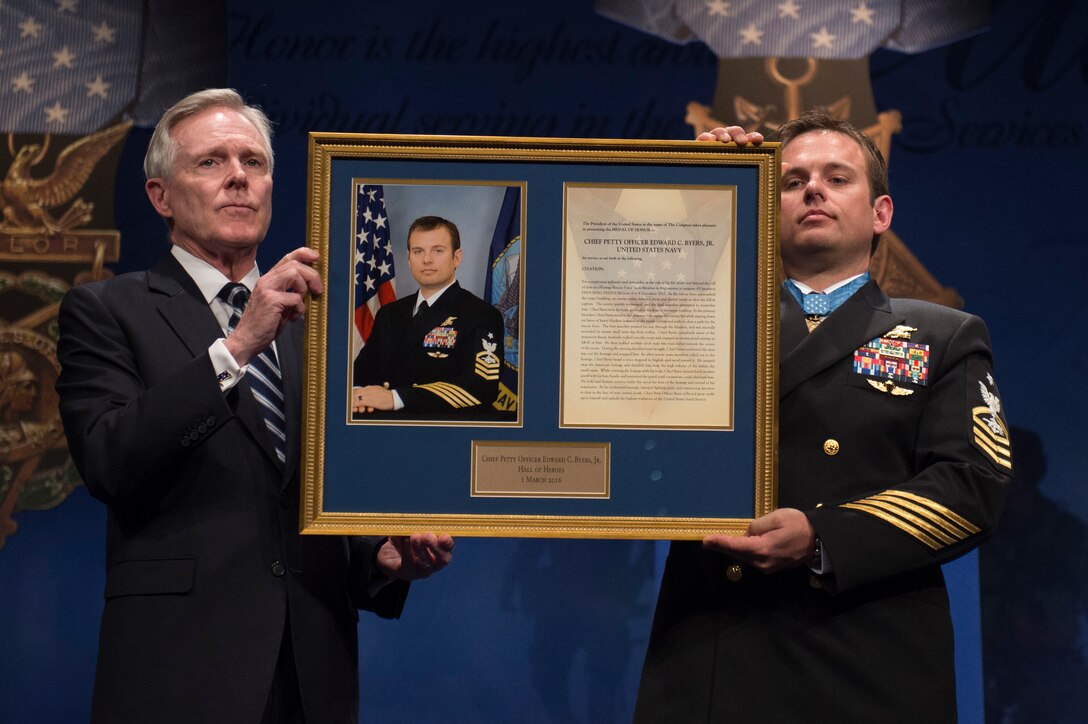 Navy Secretary Ray Mabus and Navy Senior Chief Petty Officer Edward C. Byers Jr., a Medal of Honor recipient, hold a plaque honoring Byers during a ceremony to induct him into the Hall of Heroes at the Pentagon, March 1, 2016. DoD photo by Air Force Senior Master Sgt. Adrian Cadiz