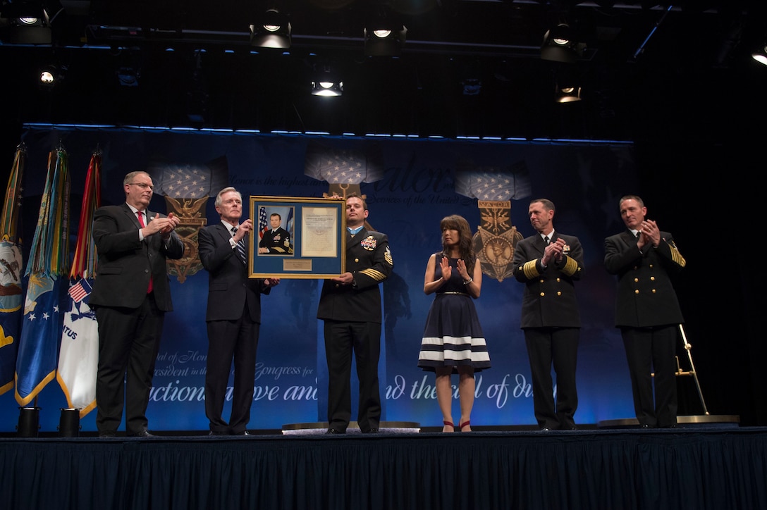 Deputy Defense Secretary Bob Work, left, applauds as Navy Secretary Ray Mabus and Navy Senior Chief Petty Officer Edward C. Byers Jr. hold a plaque honoring Byers during a ceremony to induct him into the Hall of Heroes at the Pentagon, March 1, 2016. DoD photo by Air Force Senior Master Sgt. Adrian Cadiz