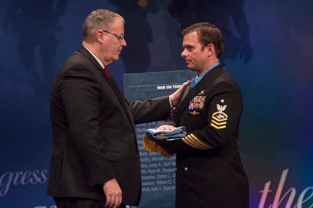 Deputy Defense Secretary Bob Work presents Navy Senior Chief Petty Officer Edward C. Byers Jr. the Medal of Honor flag during a ceremony to induct him into the Hall of Heroes at the Pentagon, March 1, 2016. DoD photo by Senior Master Sgt. Adrian Cadiz