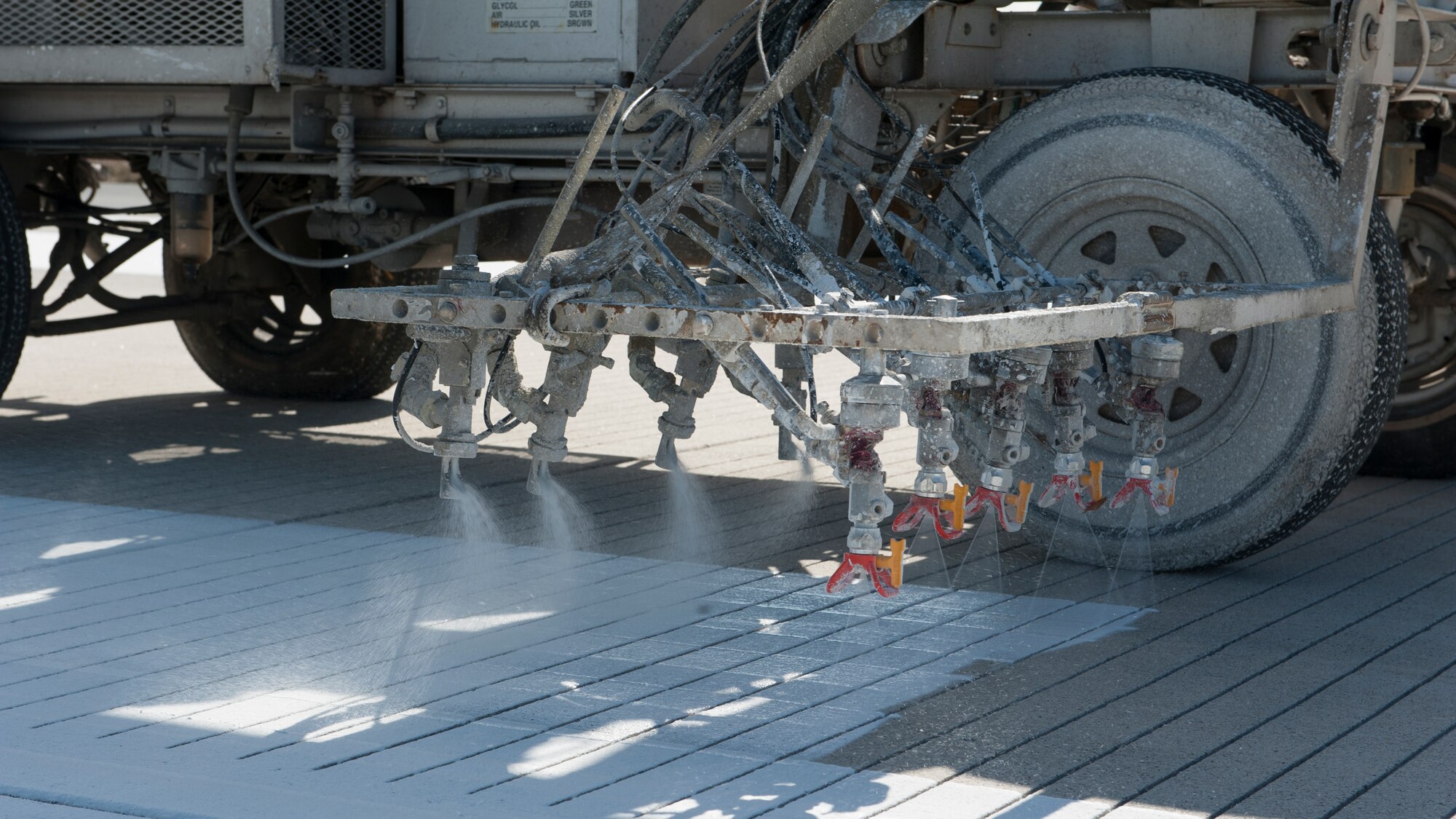 White paint is sprayed onto Runway 14-32 by a Mullen’s Markings crew as part of an ongoing runway construction project Feb. 26, 2016, at Dover Air Force Base, Del. The shortened Runway 14-32 will be used as is until August to allow construction on its intersection with Runway 01-19. (U.S. Air Force photo/Senior Airman Zachary Cacicia)
