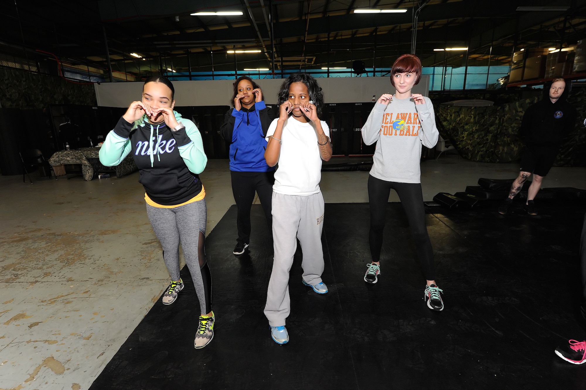 Participants of the 436th Security Forces Squadron Safety and Self-Defense Strategy program get into a fighting stance with arms raised to protect their faces Feb. 26, 2016, at Dover Air Force Base, Del. Defensive and offensive moves were taught to the women during the training by security forces personnel. (U.S. Air Force photo/Greg L. Davis)
