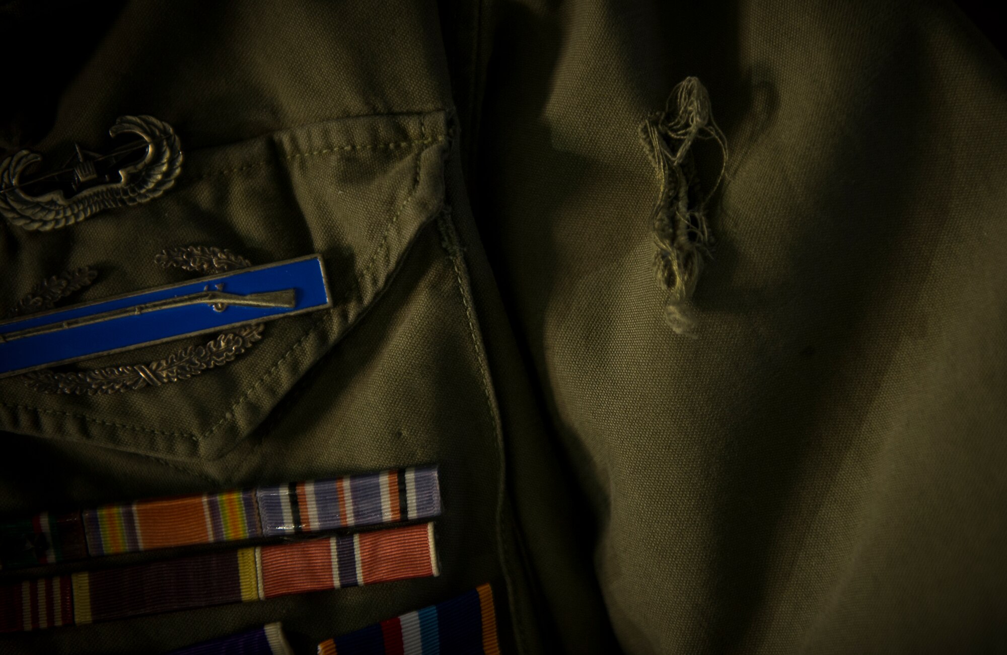 A small hole indicates a shrapnel wound on U.S. Army Private 1st Class (Sep.) Lynn Aas’ jacket during an interview at the Dakota Territory Air Museum in Minot, N.D., Feb. 18, 2016. Aas served as a combat infantry rifleman during the Battle of the Bulge. (U.S. Air Force photo/Senior Airman Apryl Hall)