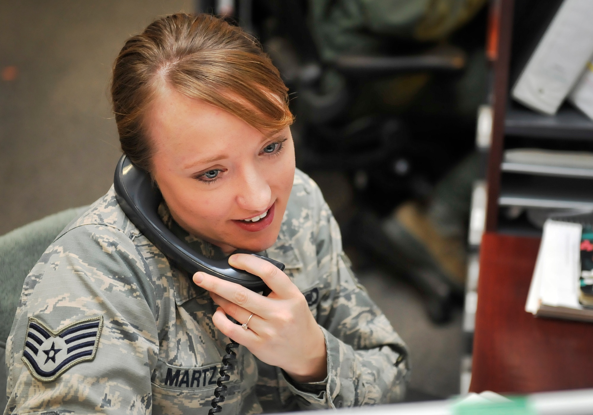 Staff Sgt. Joy Martz, 603rd Air and Space Operations Center Air Mobility Division NCO in charge of training, makes a phone call Feb. 19, 2016, at Ramstein Air Base, Germany. Martz is from Fort Collins, Colorado and joined the Air Force in 2010. She has been stationed at Cannon Air Force Base, New Mexico, Incirlik Air Base, Turkey and now Ramstein Air Base, Germany. (U.S. Air Force photo/Airman 1st Class Larissa Greatwood)