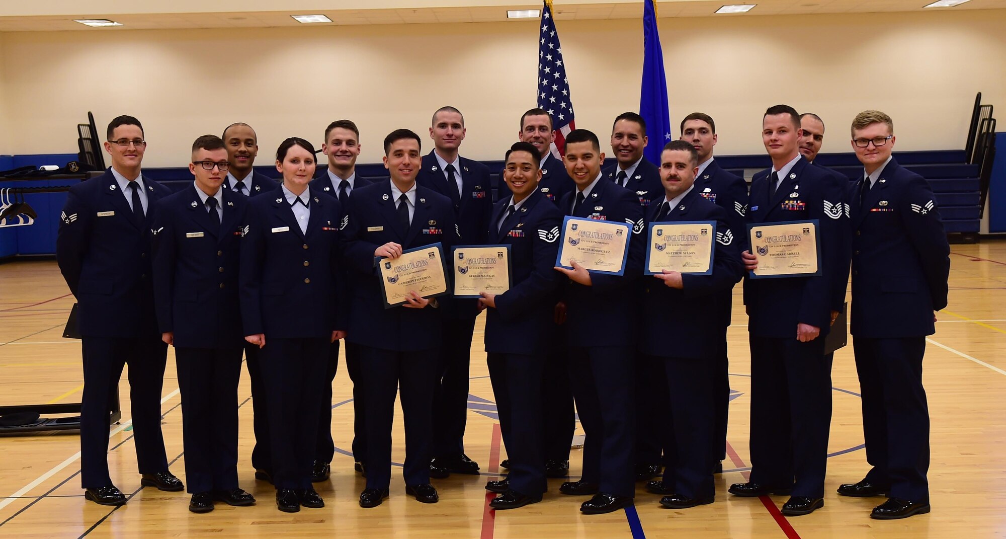 Team Buckley members stand together after being promoted to their next ranks Feb. 29, 2016, at the Buckley Fitness Center on Buckley Air Force Base, Colo. A promotion ceremony is a time-honored tradition in the Air Force, allowing co-workers, family and friends to support and congratulate Airmen on their promotion. (U.S. Air Force photo by Airman 1st Class Gabrielle Spradling/Released)