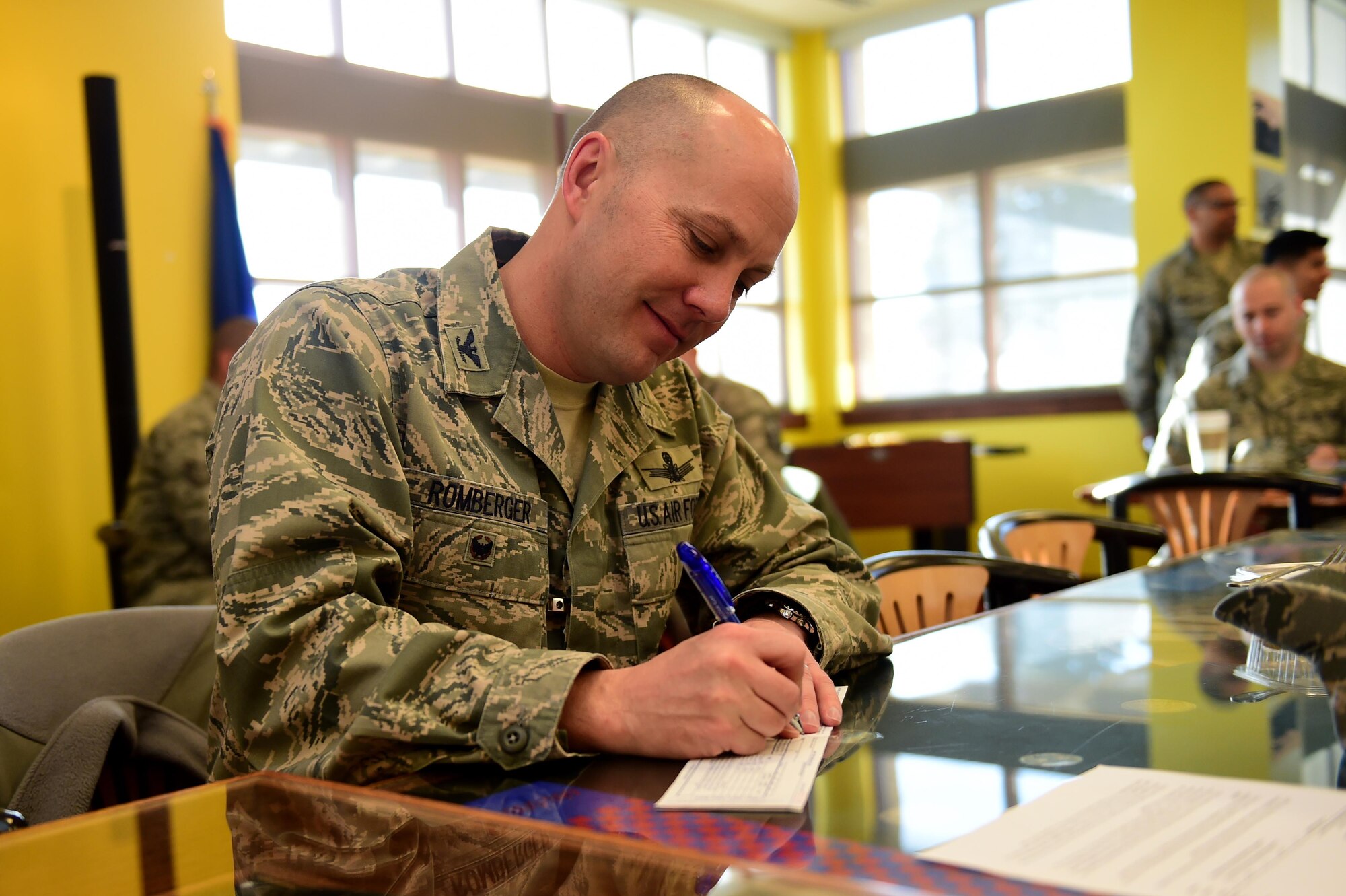Col. Scott Romberger, 460th Space Wing vice commander, signs the first Air Force Assistance Fund donation form Mar. 1, 2016, during the breakfast kickoff at the Panther Den on Buckley Air Force Base, Colo. The breakfast raised donations for the AFAF to help Air Force active-duty, reservists, guard, retirees and dependents, including surviving spouses. (U.S. Air Force photo by Airman 1st Class Gabrielle Spradling/Released)