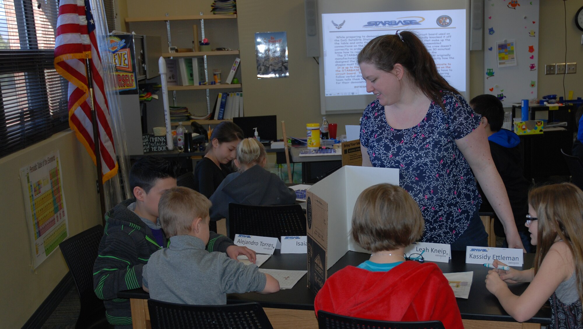 PETERSON AIR FORCE BASE, Colo. – STARBASE Academy instructor Jessica Rundley, watches fifth-graders from Madison Elementary School construct a circuit board using points plotted by classmates on the opposite side of a divider. If the directions are correctly followed a light on the circuit board will come on. (U.S. Air Force Photo by Dave Smith)