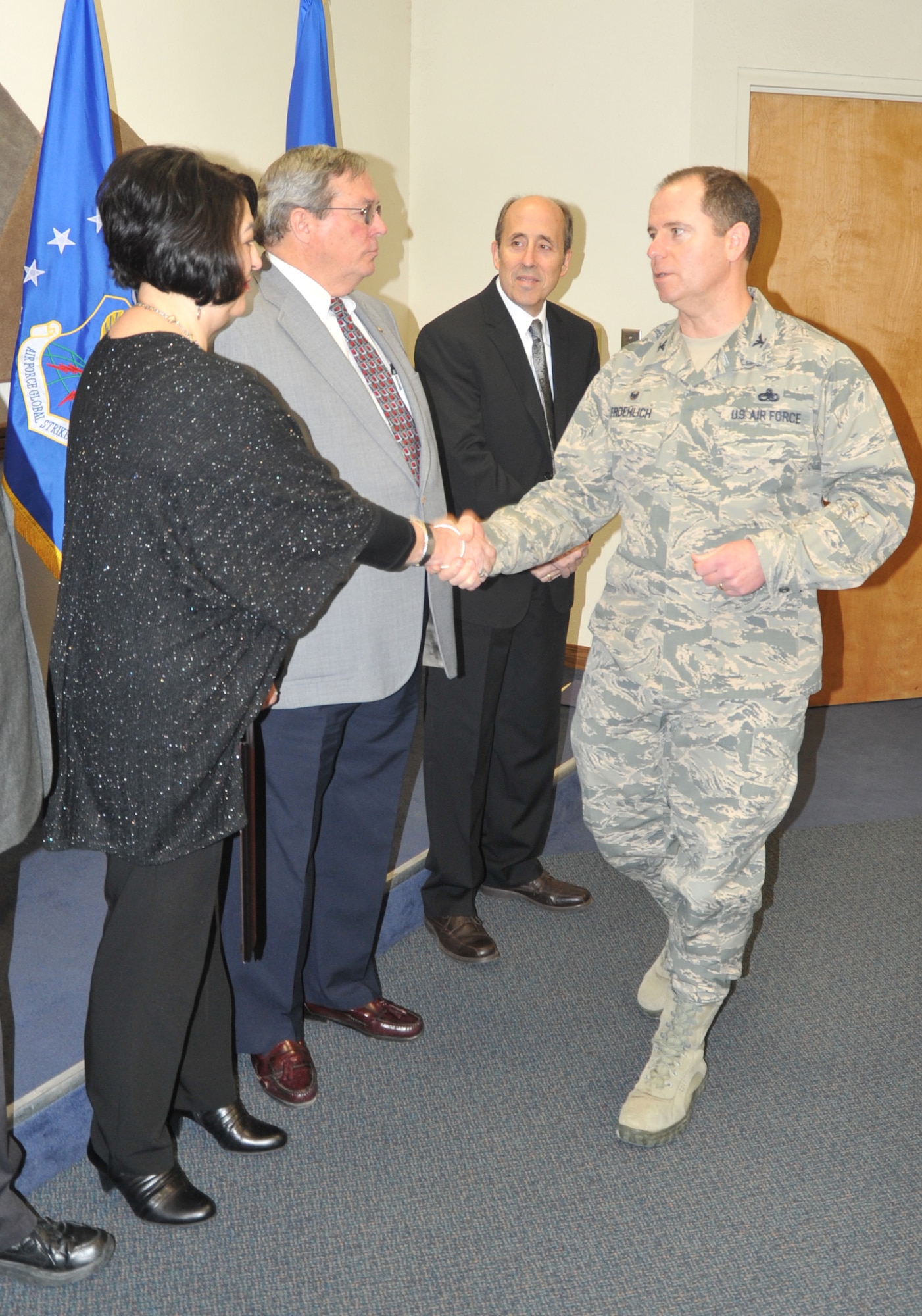 Col. Eric Froehlich, 377th Air Base Wing commander, coins Ofelia Mejiaortega for being named Air Force Materiel Command Alternative Dispute Resolution Practitioner of the Year for 2015 at a staff meeting Feb. 24. (Air Force photo by Jim Fisher) (Photo by Jim Fisher)
