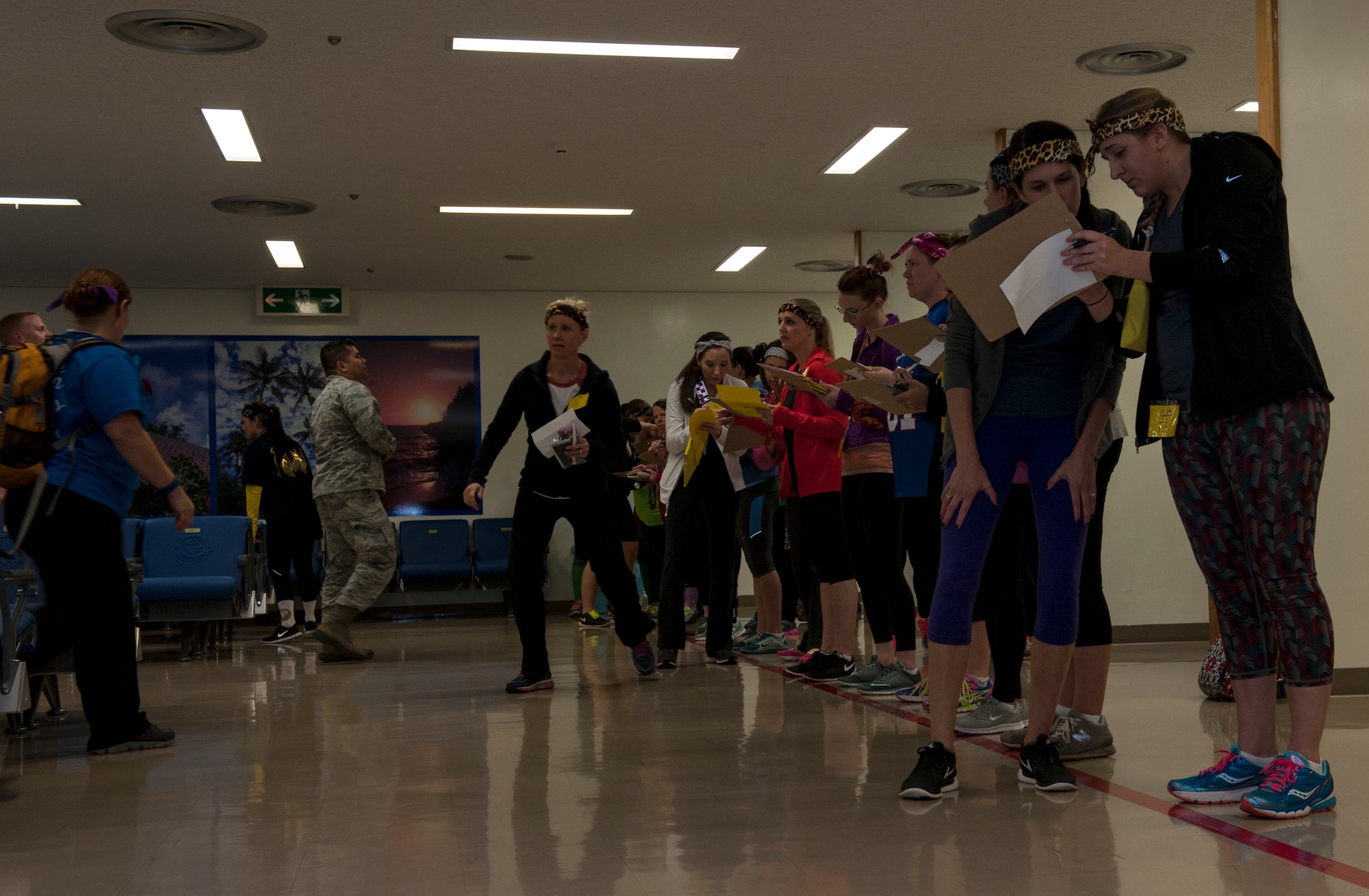 Spouses work through a challenge during Team Kadena Spouses’ Amazing Race Feb. 25, 2016, at Kadena Air Base, Japan. For this challenge, they could only whisper to their teammates as they searched for names on a manifest. (U.S. Air Force photo by Airman 1st Class Lynette M. Rolen)
