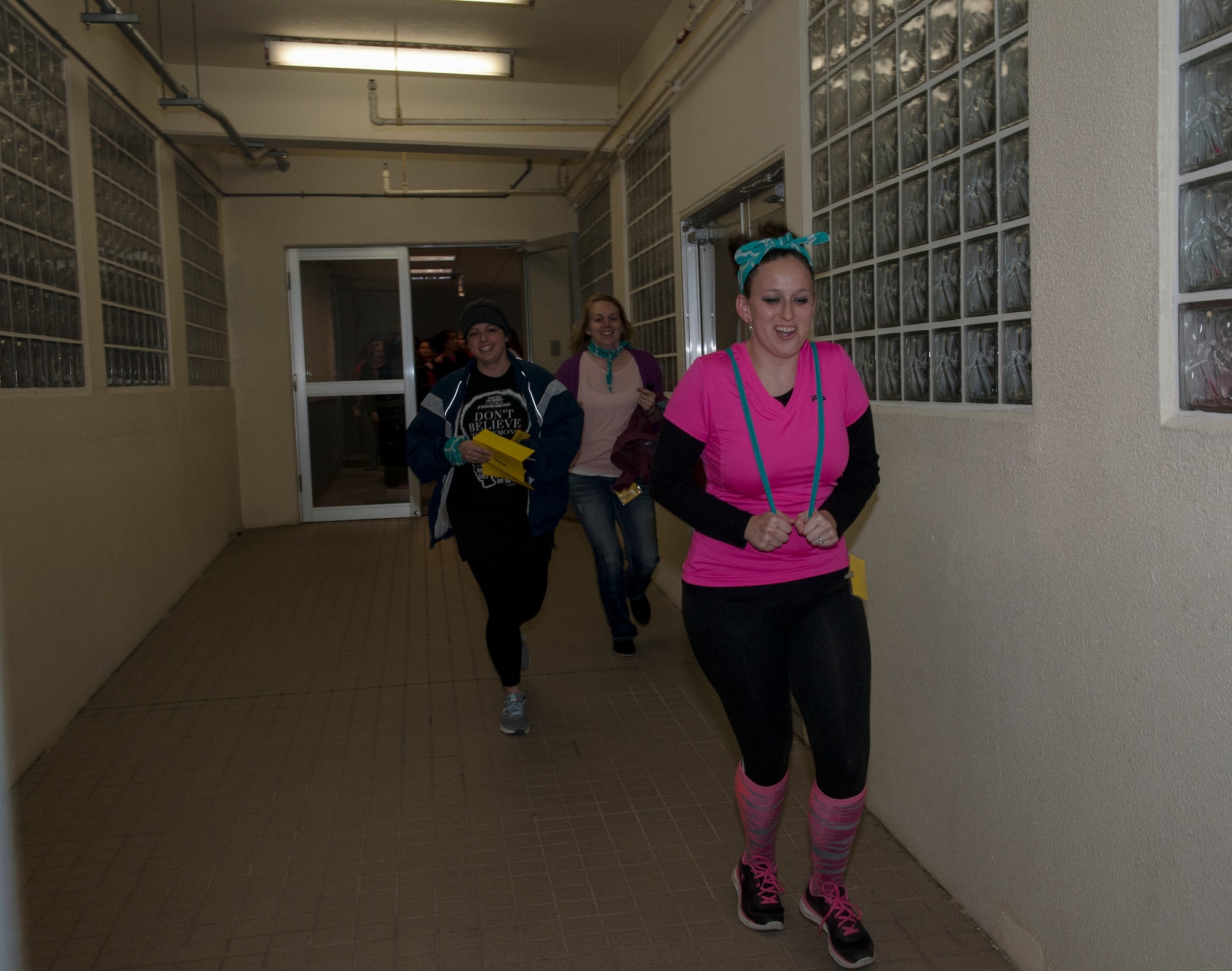 Spouses from the 18th Munitions Squadron race down a hallway to their challenge during Team Kadena Spouses’ Amazing Race Feb. 25, 2016, at Kadena Air Base, Japan. One of the challenges took place at the Air Mobility Command Terminal, where competitors had to arrange luggage, race luggage carts, and find names from a manifest that had been dispersed among chairs. (U.S. Air Force photo by Airman 1st Class Lynette M. Rolen)