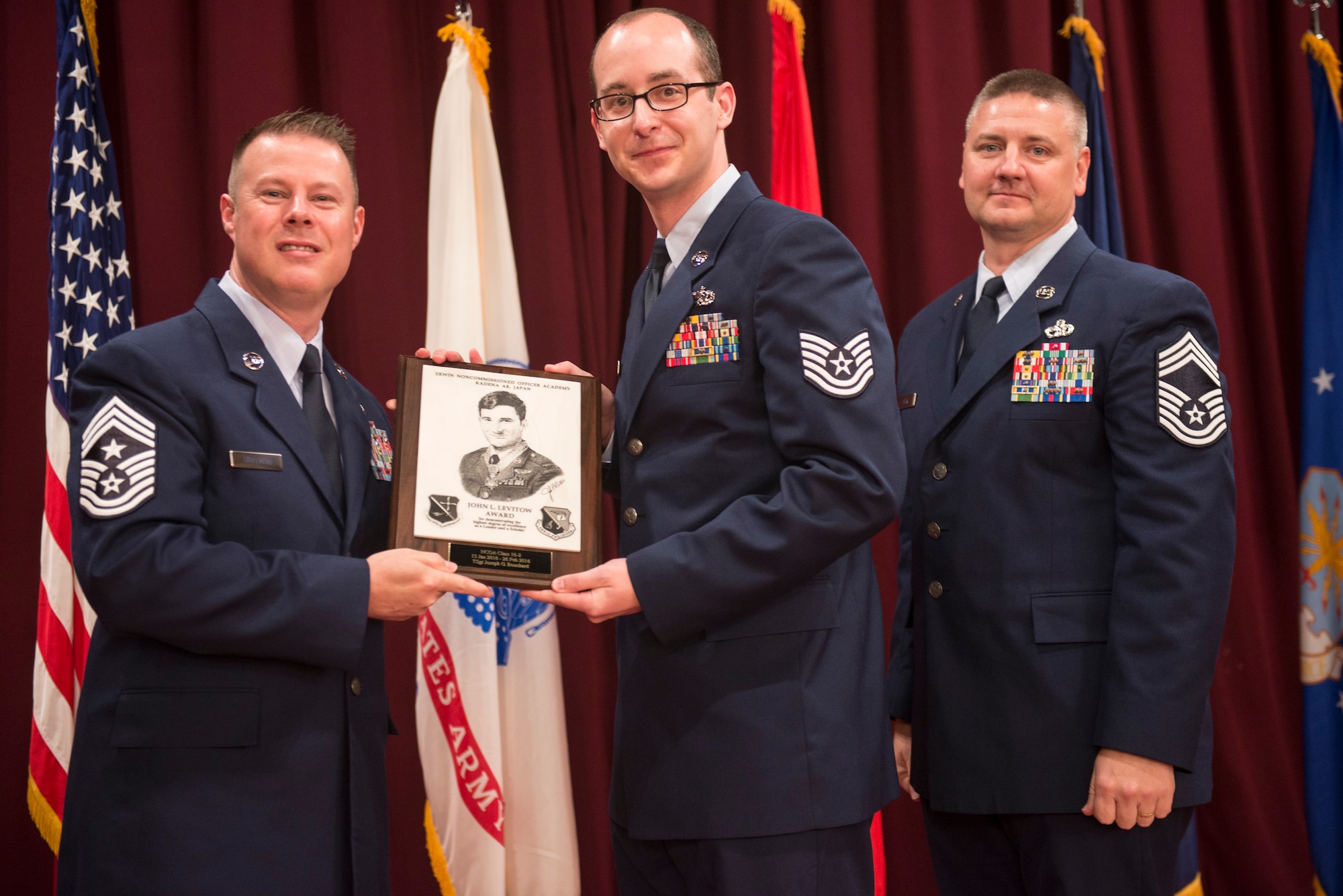 U.S. Air Force Tech. Sgt. Joseph Bouchard, 35th Maintenance Squadron, Misawa Air Base, Japan, accepts the John L. Levitow Award during the graduation ceremony for NCO Academy Class 16-2 Feb. 26, 2016, at Kadena Air Base, Japan. The John L. Levitow Award is presented to the student who earns the highest average score on evaluations and most embodies the Air Force core values. (U.S. Air Force photo by Senior Airman Omari Bernard)