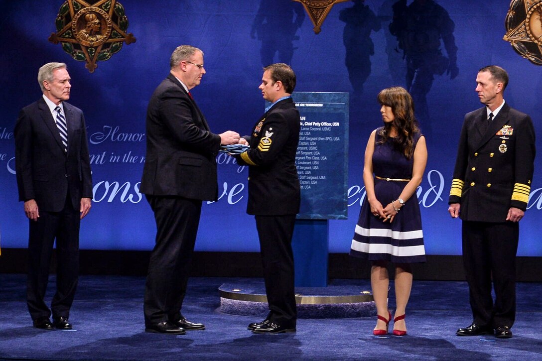 Deputy Defense Secretary Bob Work presents the Medal of Honor flag to Navy Senior Chief Petty Officer Edward C. Byers Jr. during the Hall of Heroes ceremony at the Pentagon, March 1, 2016.  Byers received the Medal of Honor for actions in Afghanistan during a White House ceremony, Feb. 29, 2016. Photo by EJ Hersom