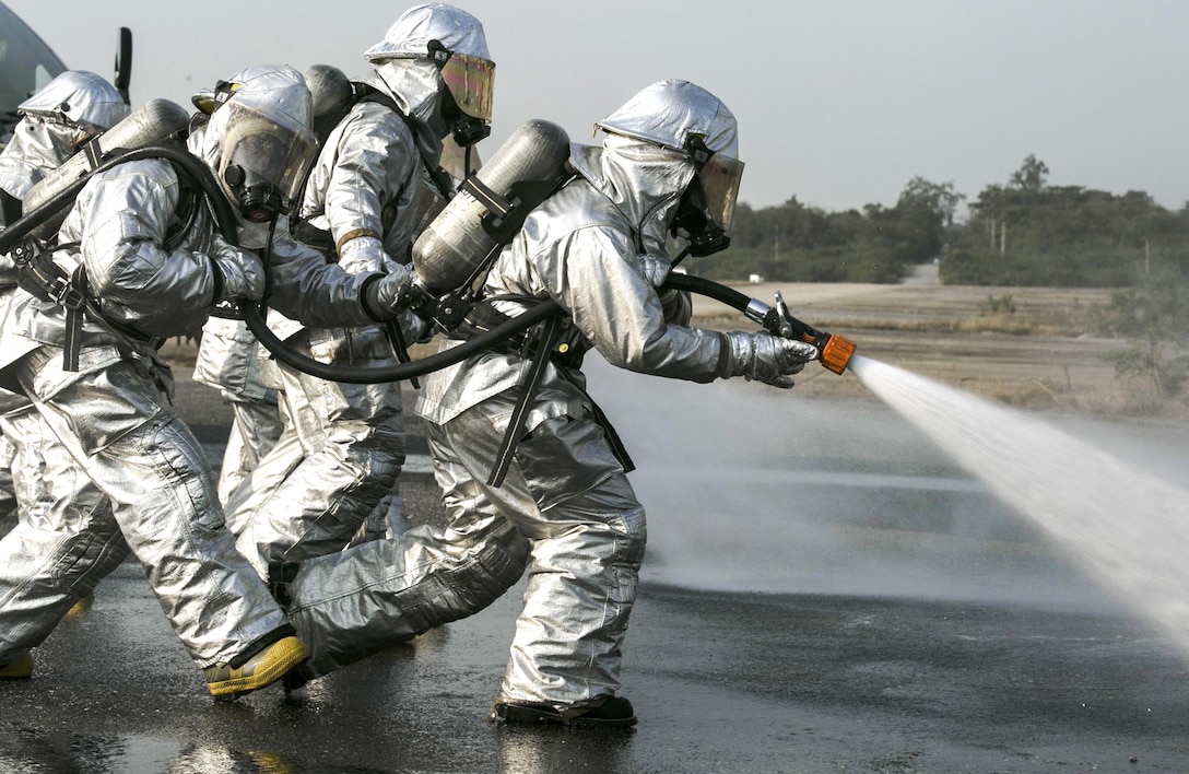 Marines spray fuel with a hose as they approach an aircraft engulfed in fire during a training event as part of Cobra Gold 16 in Utapao, Thailand, Feb. 19, 2016. The Marines are with Marine Wing Support Squadron 172. Cobra Gold is a multinational training exercise. Marine Corps photo By Cpl. William Hester