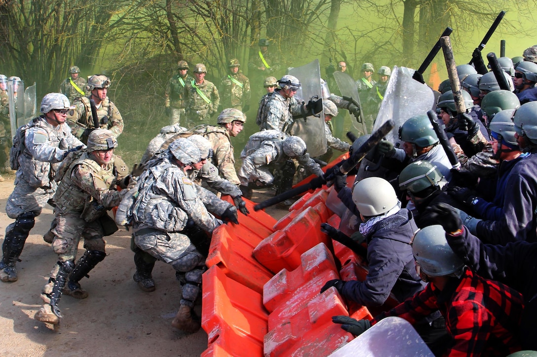 U.S. soldiers, left, engage role players acting as angry protesters during crowd control training at the Joint Multinational Readiness Center in Hohenfels, Germany, Feb. 25, 2016. Army photo by Staff Sgt. Thomas Duval