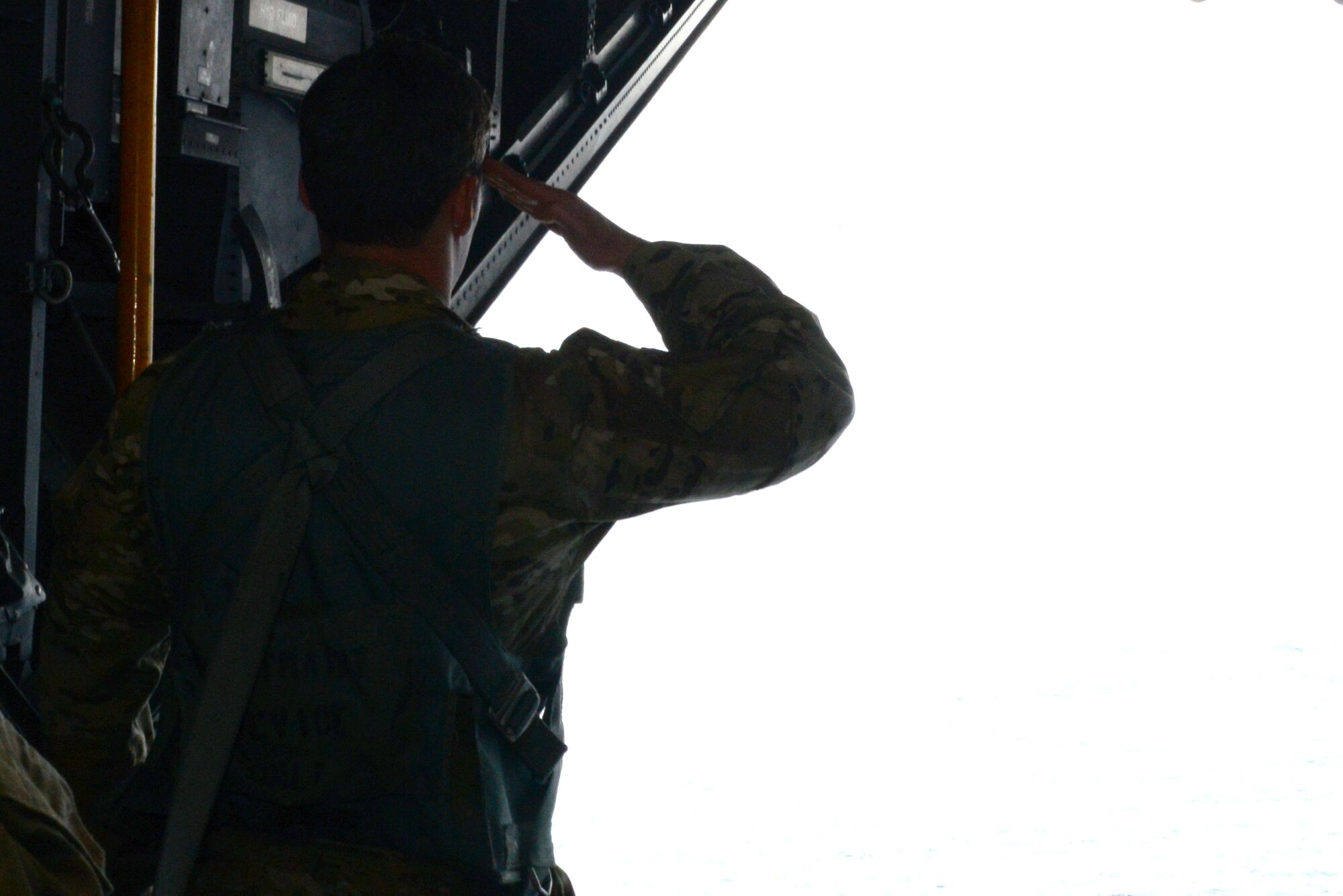 A pararescueman from the 320th Special Tactics Squadron pays his respects to the crew and passengers of Stray 59 from a U.S. Air Force MC-130H Combat Talon II off the coast of the Philippines Feb. 26, 2016. The Stray 59 memorial flight is conducted annually to honor those who were lost 35 years ago when a 1st SOS MC-130E, call sign STRAY 59, crashed during an exercise killing eight crew members and 15 passengers.  Two of the passengers were combat controllers from the 320th Special Tactics Squadron.   (U.S. Air Force photo by Master Sgt. Kristine Dreyer, 353rd Special Operations Group)