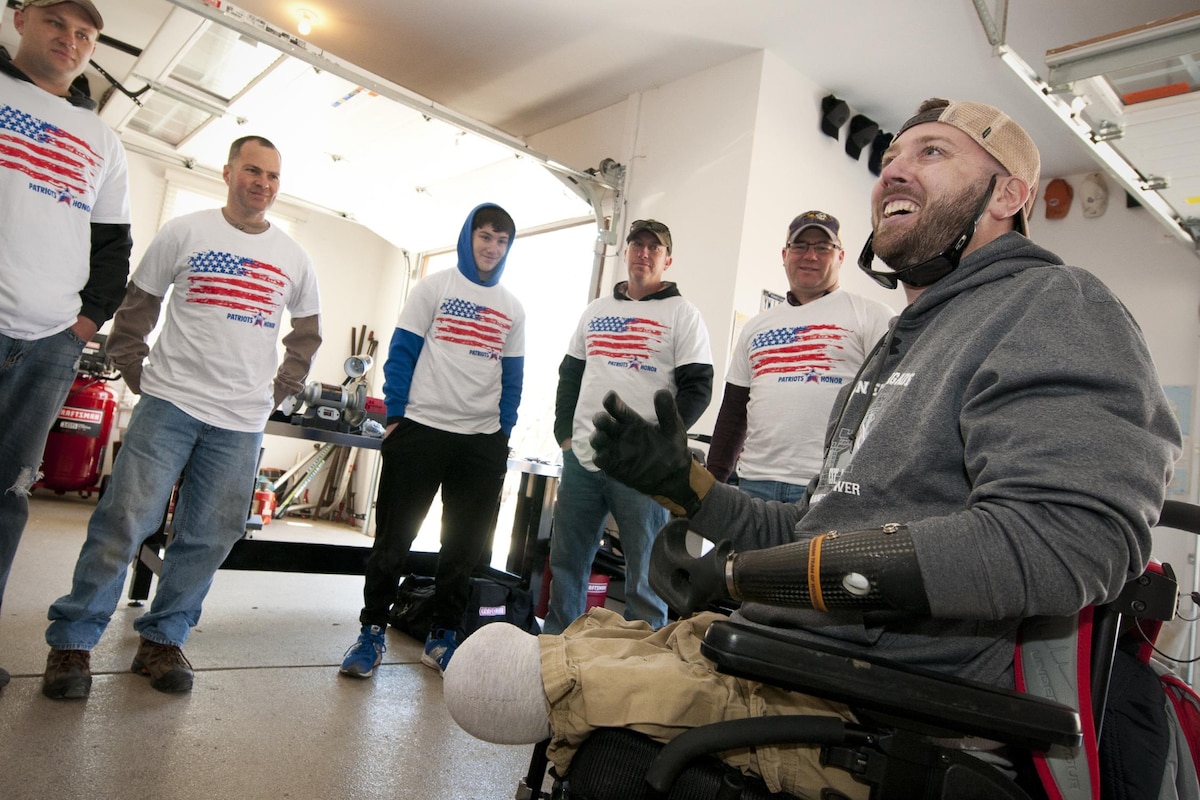 U.S. Army Sgt. (ret.) Adam Keys expresses his gratitude to a group of 459th Aircraft Maintenance Squadron members at his home in Annapolis, Md., Feb. 27, 2016. Ten members of the 459 AMXS volunteered on behalf of the nonprofit Patriots Honor to unpack, build and install workbenches, power tools and roll-aways in Keys’ garage in effort to help make dreams come true for Wounded Warriors. Keys, a triple amputee who has endured more than 130 surgeries due to injuries sustained from an IED explosion in Afghanistan in 2010, intends to use the equipment to pursue his hobby of building small engines and model cars. (U.S. Air Force photo by Staff Sgt. Kat Justen)