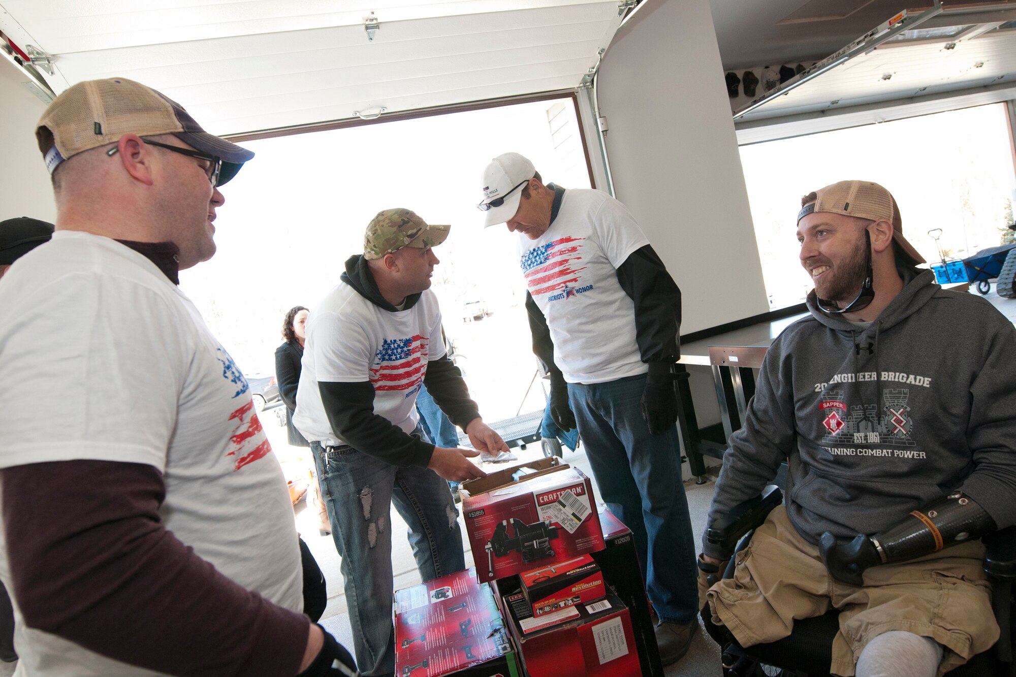 Senior Master Sgt. Bradley Otey, 459th Aircraft Maintenance Squadron flight chief (left), shares a laugh with U.S. Army Sgt. (ret.) Adam Key (right) as other 459th members unbox power tools in Keys’ garage in Annapolis, Md., Feb. 27, 2016. Ten members of the 459 AMXS volunteered on behalf of the nonprofit Patriots Honor to unpack, build and install workbenches, power tools and roll-aways in Keys’ garage in an effort to help make dreams come true for Wounded Warriors. Keys, a triple amputee who has endured more than 130 surgeries due to injuries sustained from an IED explosion in Afghanistan in 2010, intends to use the equipment to pursue his hobby of building small engines and model cars. (U.S. Air Force photo by Staff Sgt. Kat Justen)