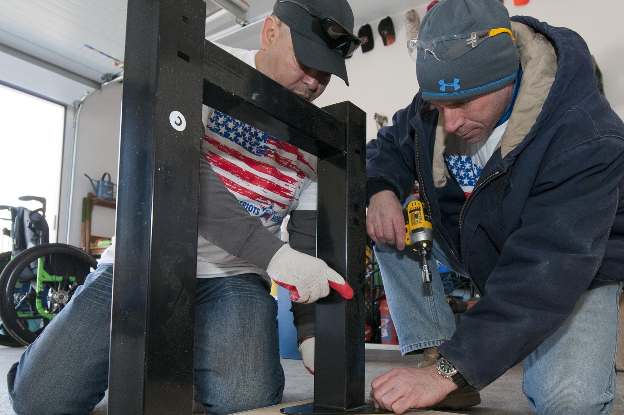 Technical Sgt. Bayardo Rodriguez, 459th Aircraft Maintenance Squadron crew chief (left), and Senior Master Sgt. Karl Schoennagel, 459 AMXS ground equipment flight chief (right), assemble a workbench at U.S. Army Sgt. (ret.) Adam Keys’ home in Annapolis, Md., Feb. 27, 2016. Ten members of the 459 AMXS volunteered on behalf of the nonprofit Patriots Honor to unpack, build and install workbenches, power tools and roll-aways in Keys’ garage in an effort to help make dreams come true for Wounded Warriors. Keys, a triple amputee who has endured more than 130 surgeries due to injuries sustained from an IED explosion in Afghanistan in 2010, intends to use the equipment to pursue his hobby of building small engines and model cars. (U.S. Air Force photo by Staff Sgt. Kat Justen)