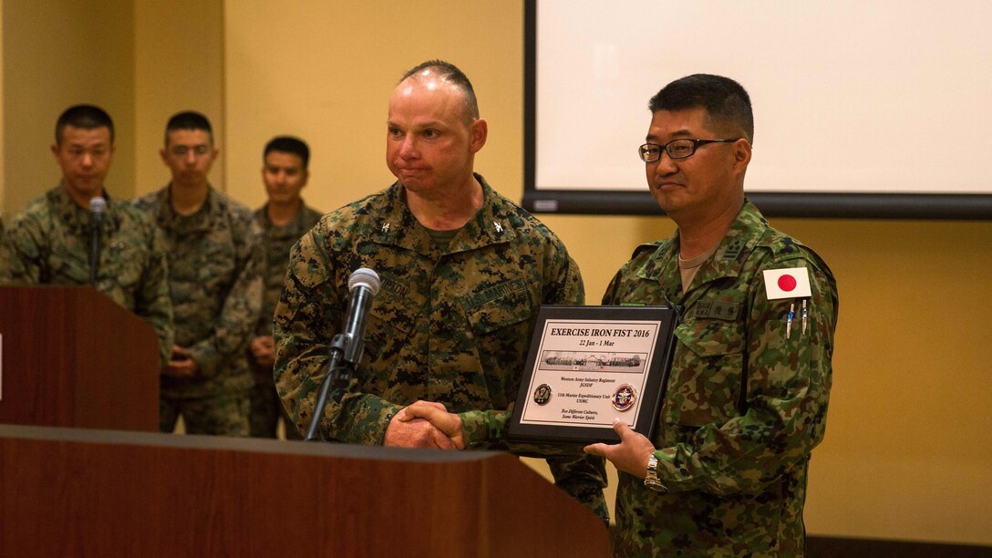 U.S. Marine Corps Col. Clay Tipton, commanding officer, 11th Marine Expeditionary Unit, presents a plaque to Col. Yoshiyuki Goto, regimental commander, Western Army Infantry Regiment, Japan Ground Self-Defense Force, at Marine Corps Base Camp Pendleton, California, March 1, 2016, during the closing ceremony of Exercise Iron Fist 2016. The ceremony concluded the 11th iteration of Exercise Iron Fist, an annual bilateral amphibious training exercise conducted by the USMC and JGSDF. Over the course of five weeks, Marines with 11th Marine Expeditionary Unit worked alongside the soldiers of the WAIR to complete an aggressive and progressive training schedule designed to improve their amphibious operational capabilities. 