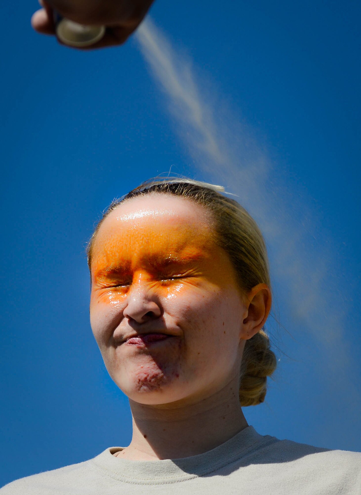 U.S. Air Force Airman 1st Class Hannah McCoy, 20th Security Forces Squadron journeyman, gets pepper sprayed during training at Shaw Air Force Base, S.C., Feb. 29, 2016. During orientation training all new security forces Airmen experience pepper spray to better understand its effects. (U.S. Air Force photo by Senior Airman Jensen Stidham)