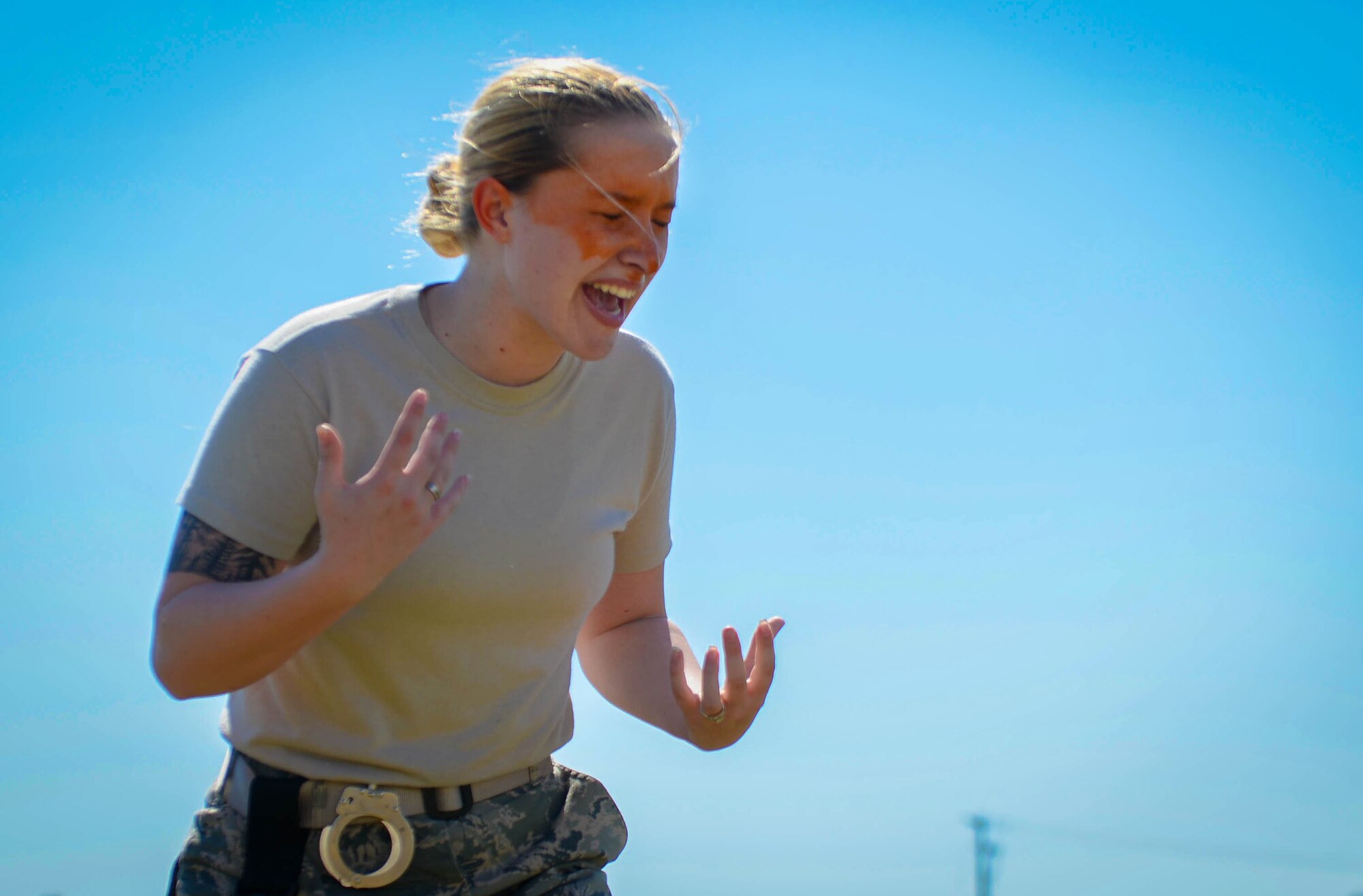 U.S. Air Force Airman 1st Class Hannah McCoy, 20th Security Forces Squadron journeyman, reacts to pepper spray during training at Shaw Air Force Base, S.C., Feb. 29, 2016. McCoy had to count to ten before opening her eyes and running to four stations to engage simulated perpetrators. (U.S. Air Force photo by Senior Airman Jensen Stidham)