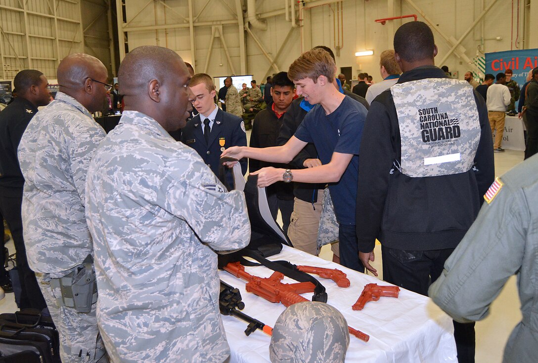 Master Sgt. Rickie Bellamy and Tech. Sgt. James Bryant, 315th Security Forces Squadron, had a very popular demonstration table filled with rubber training weapons, flack vests and helmets for students to try out  at the Joint Base Charleston Tuskegee Airmen Career Day Feb. 25, 2016. The 315th Airlift Wing's first Tuskegee Airmen Career Day drew  over 130 local teenage boys to Joint Base Charleston, S.C. to learn about careers in aviation. The event also celebrated the story of the first black pilots in the American military – the Tuskegee Airmen. (courtesy photo by Senior Master Sgt. Eric Keys)
