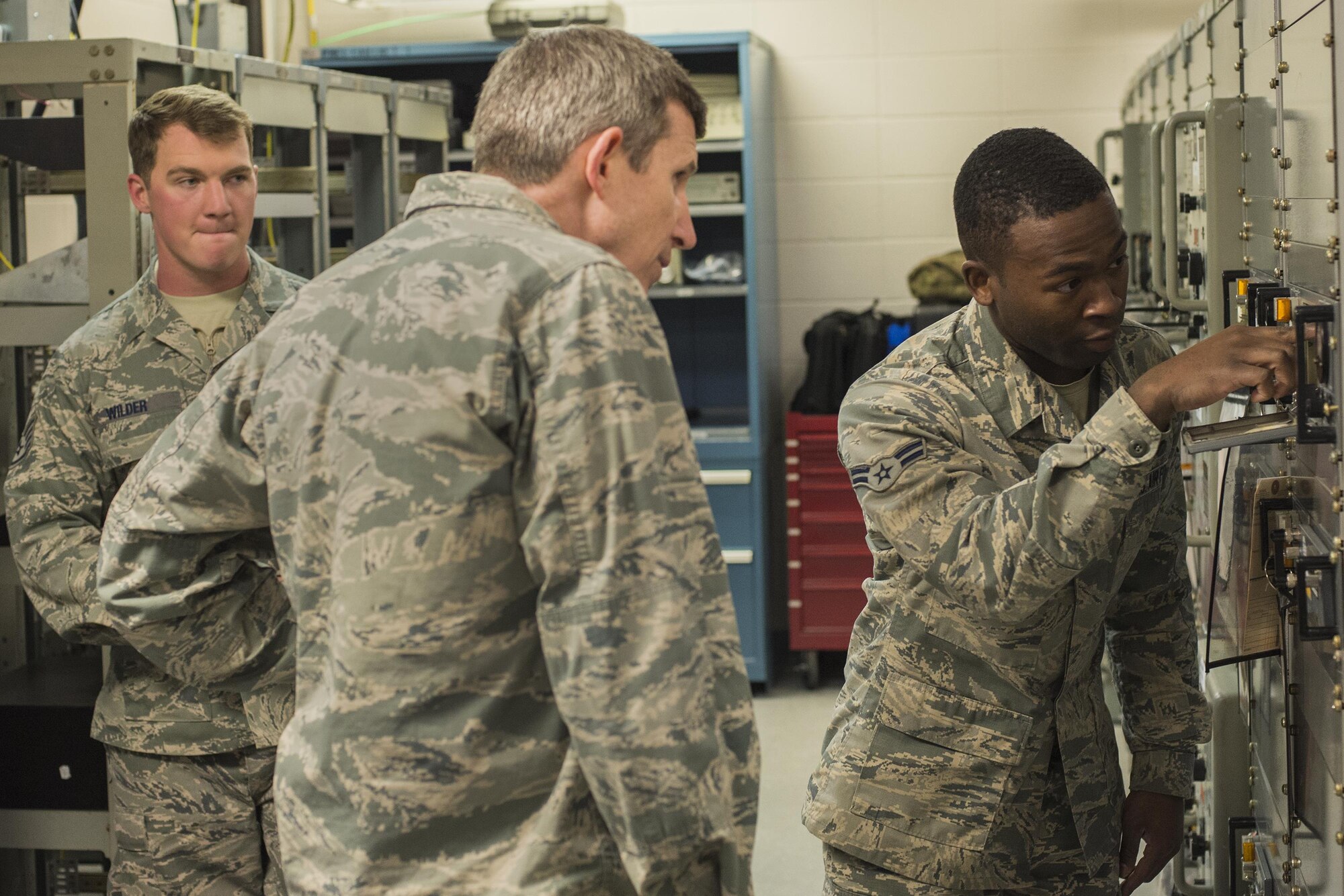 U.S. Air Force Staff Sgt. Gary Wilder, 23d Operations Support Squadron, airfield systems supervisor, left, and Col. Thomas Kunkel, 23d Wing commander, watch as Airman 1st Class Kendrick McKnuckles, 23d OSS airfield systems technician, right, demonstrates how to use the ground air transmit receiver, Feb. 26, 2016, at Moody Air Force Base, Ga. The 23d OSS helps maintain a solid stream of communication between pilots and air traffic controllers. (U.S. Air Force photo by Airman Daniel Snider/Released)
