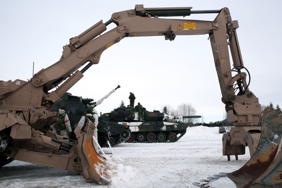An armored engineer vehicle and Norwegian tank are on display in Namsos, Norway, March 1, 2016, during Distinguished Visitor Day as part of Exercise Cold Response 16. Distinguished Visitor Day provided high-ranking personnel from all 13 participating countries an overview of the scope, intent and capabilities achieved through integration of personnel and equipment among NATO allies and partners nations. During Cold Response, more than 15,000 troops will work together, learn from each other and sustain and strengthen partnerships, operational capabilities, and coordination.