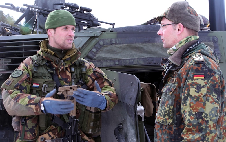 A Dutch soldier (left) talks to a German officer about the capabilities of weapons systems on display in Namsos, Norway, March 1, 2016, during Distinguished Visitor Day as part of Exercise Cold Response 16. Distinguished Visitor Day provided high-ranking personnel from all 13 participating countries an overview of the scope, intent and capabilities achieved through integration of personnel and equipment among NATO allies and partners nations. During Cold Response, more than 15,000 troops will work together, learn from each other and sustain and strengthen partnerships, operational capabilities, and coordination.