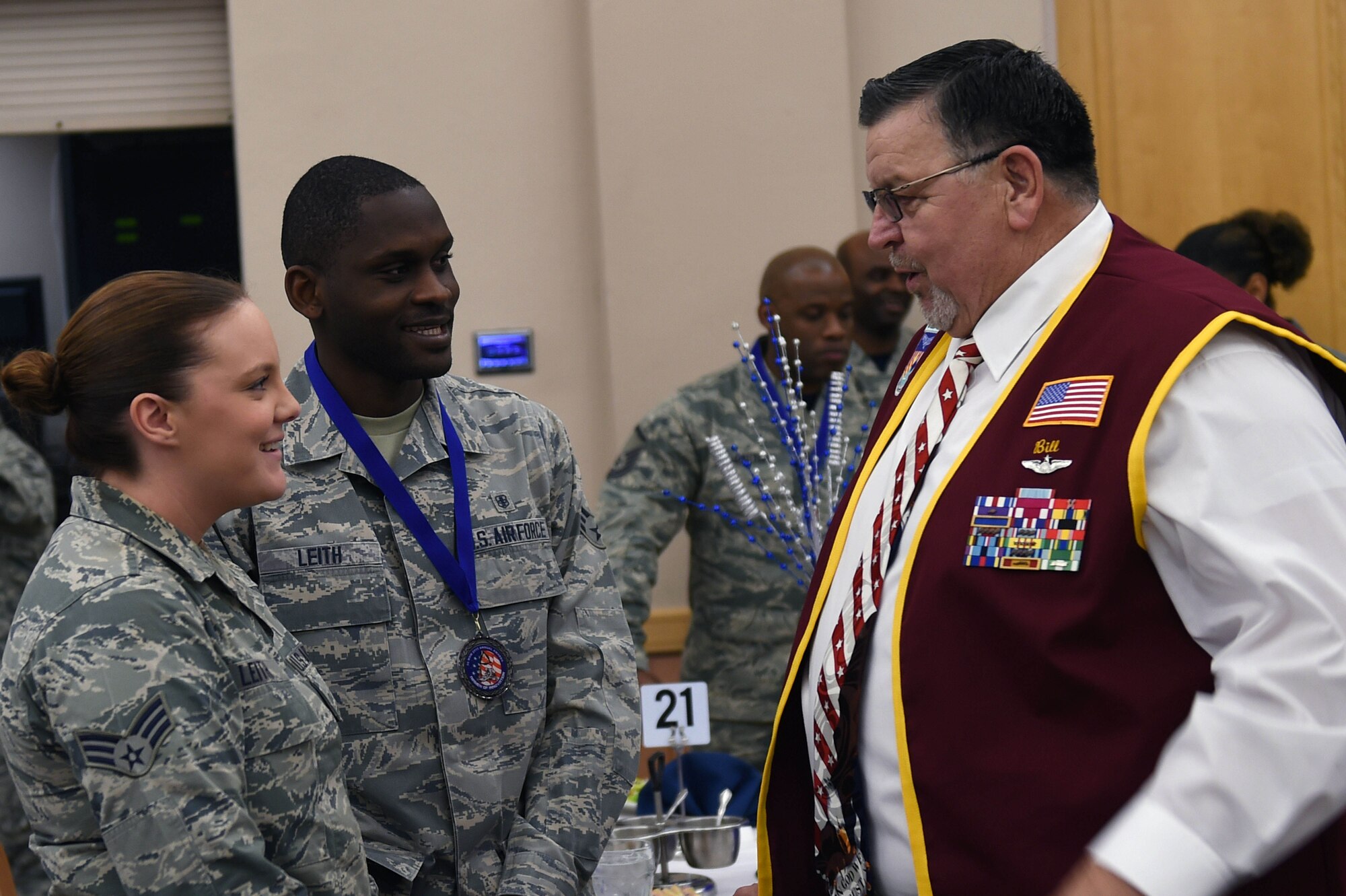 Retired Capt. William A. Robinson, former prisoner of war, visits with Senior Airman Akel Leith, 59th Medical Operations Group mental health technician, and his wife, Senior Airman Tabitha Leith, during the 59th Medical Wing annual awards luncheon. As an airman first class, Robinson spent seven and a half years as a prisoner of war in North Vietnam before his release in 1973. (U.S. Air Force photo/Staff Sgt. Jason Huddleston)