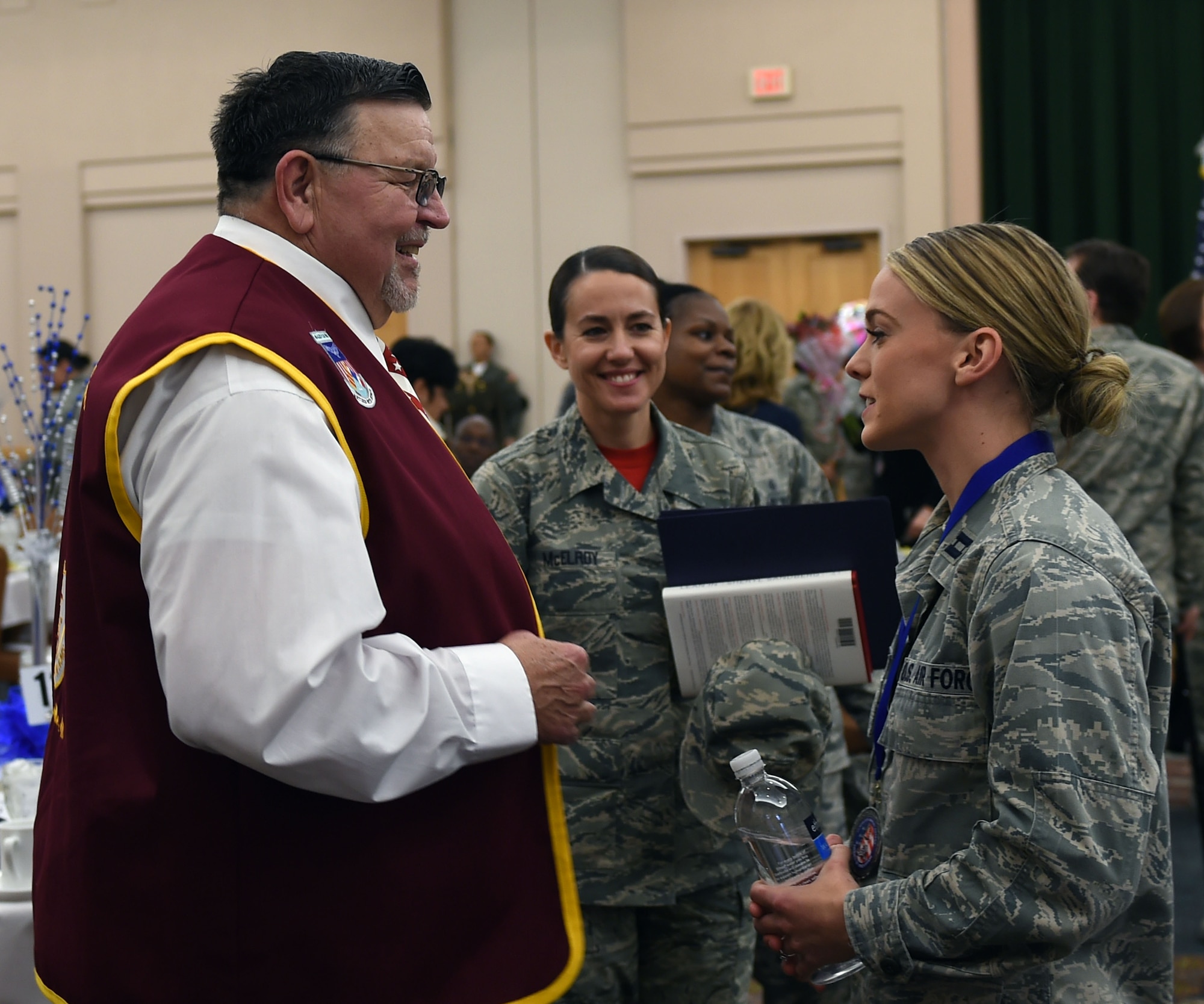 Retired Capt. William A. Robinson, former prisoner of war, speaks with Capt. Jennifer Aspinwall, 59th Medical Operations Group occupational therapy element leader, during the 59th Medical Wing annual awards luncheon. Aspinwall was selected the wing’s company grade officer of the year. As an airman first class, Robinson spent seven and a half years as a prisoner of war in North Vietnam before his release in 1973. (U.S. Air Force photo/Staff Sgt. Jason Huddleston)