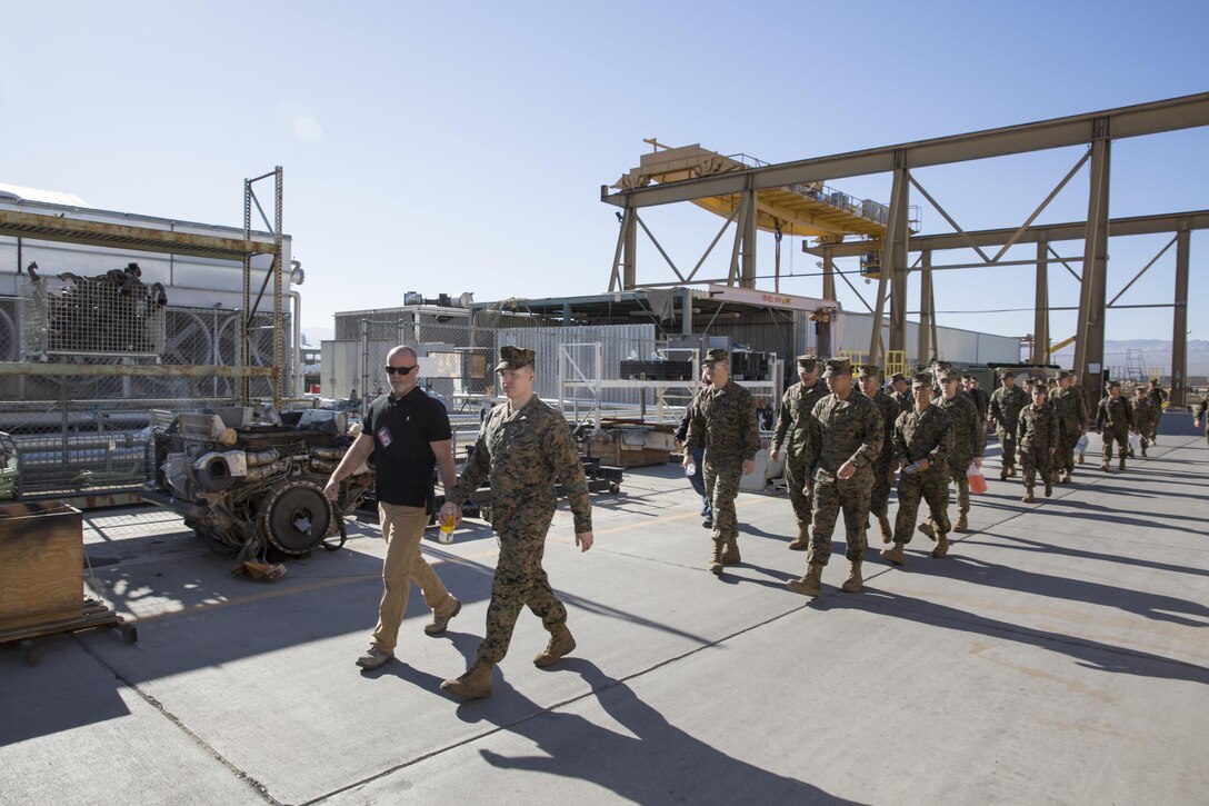 Dan Peterson, Metals Branch Head at Production Plant Barstow aboard Marine Corps Logistics Base Barstow, guides visitng Marines from Combat Logistics Battalion-453 through the exterior of PPB, Feb.19.  The CLB Marines spent the day aboard Marine Corps Logistics Base Barstow learning about the maintenance carried out at PPB and received a period of military instruction on rail operations.